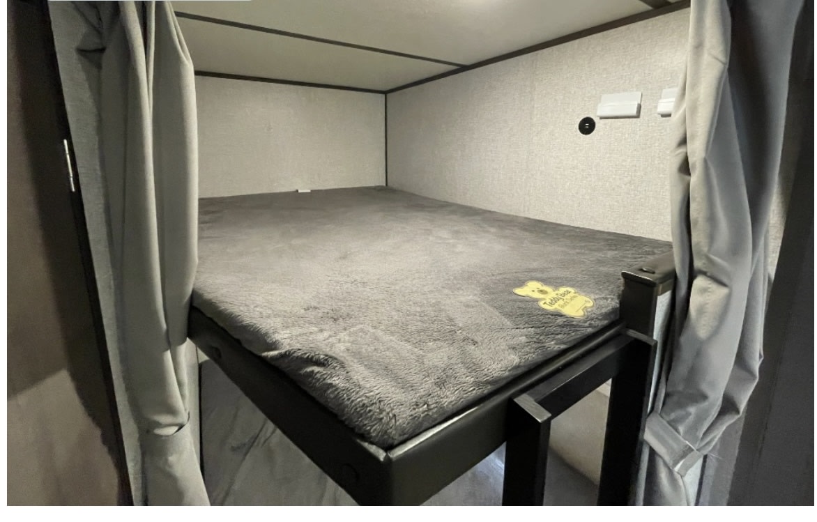 This RV rental offers a comfy bunk bed with privacy curtains & a soft gray mattress, ready for a good night's sleep.. Coleman Lantern 2021