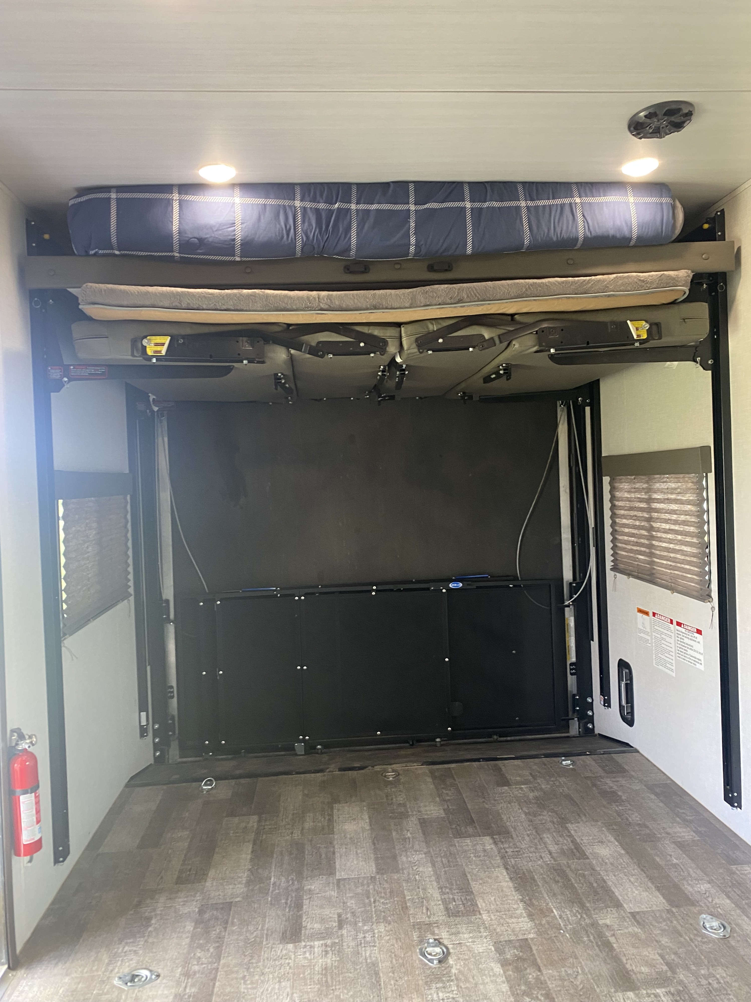 RV rental toy hauler interior: Bunk beds and seating lifted, revealing a spacious garage area with tie-downs.. Winnebago Winnebago 2021
