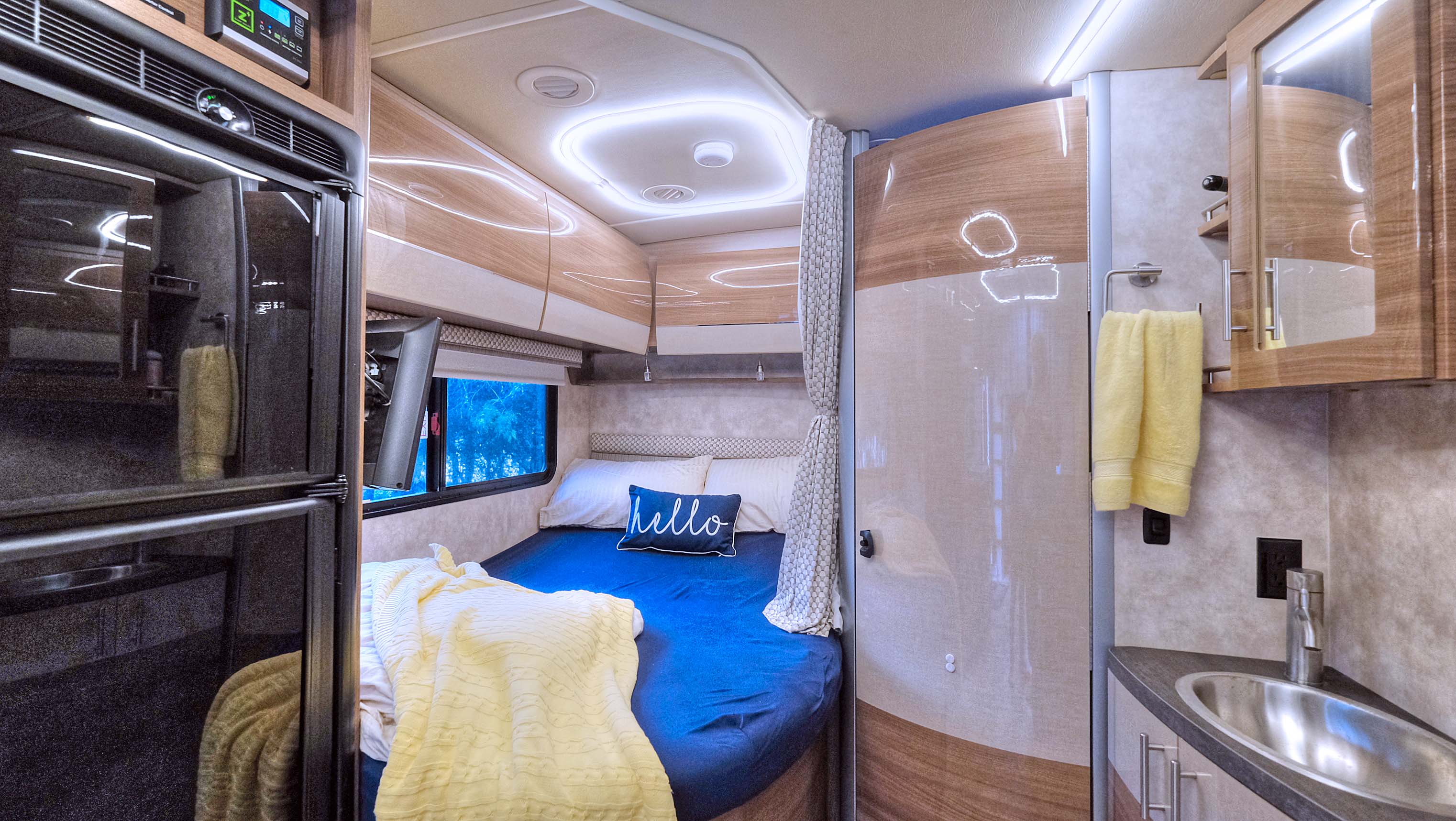 Cozy RV rental interior featuring a comfortable bed, compact kitchen sink, and modern amenities, perfect for travel adventures.. Winnebago View 2018