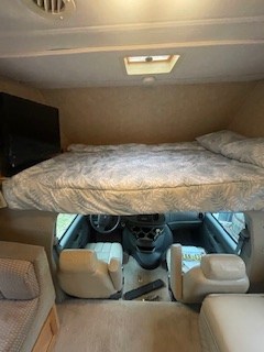 Spacious RV rental interior with a cozy cab-over bunk bed, front seating, and living area.. Dutchmen Dutchmen Motorhome 2007