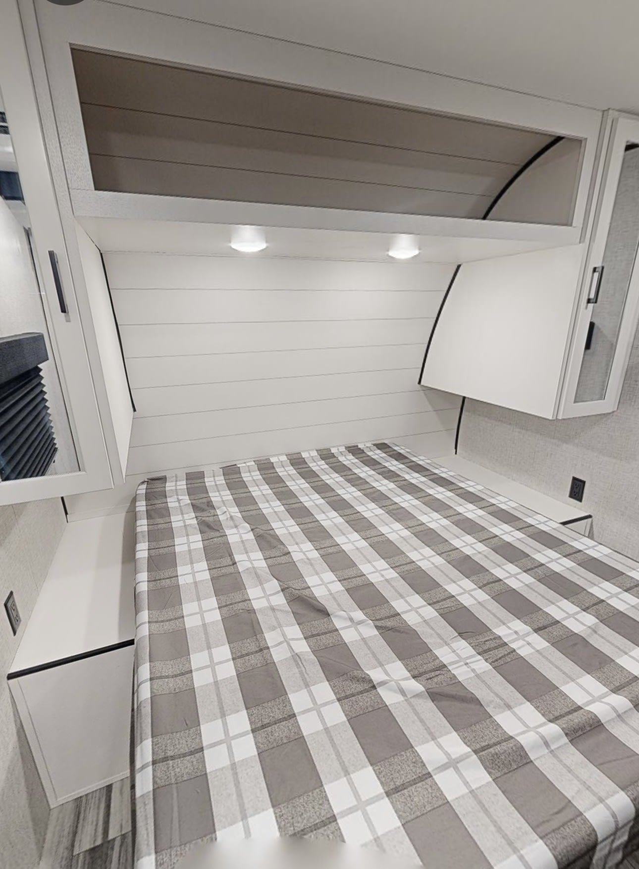RV rental bedroom features a comfy plaid bed, white shiplap wall, and functional overhead storage.. JAYCO Jay Flight SLX 2025