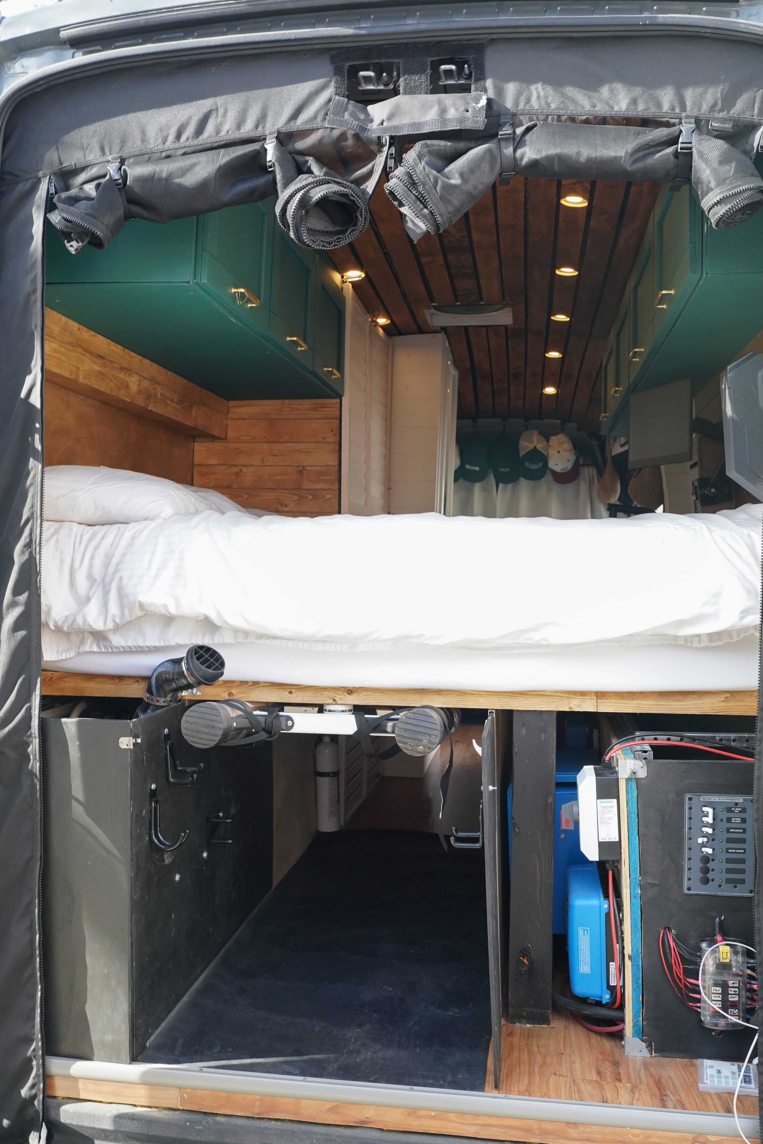 This RV rental shows a well-organized camper interior with a cozy bed, under-bed storage, and accessible electrical systems.. Ford Transit Custom 2022