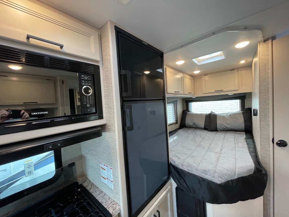 Explore this RV rental! Features a well-equipped kitchen with a microwave, fridge, plus a cozy bedroom.. Thor Freedom Elite 2022