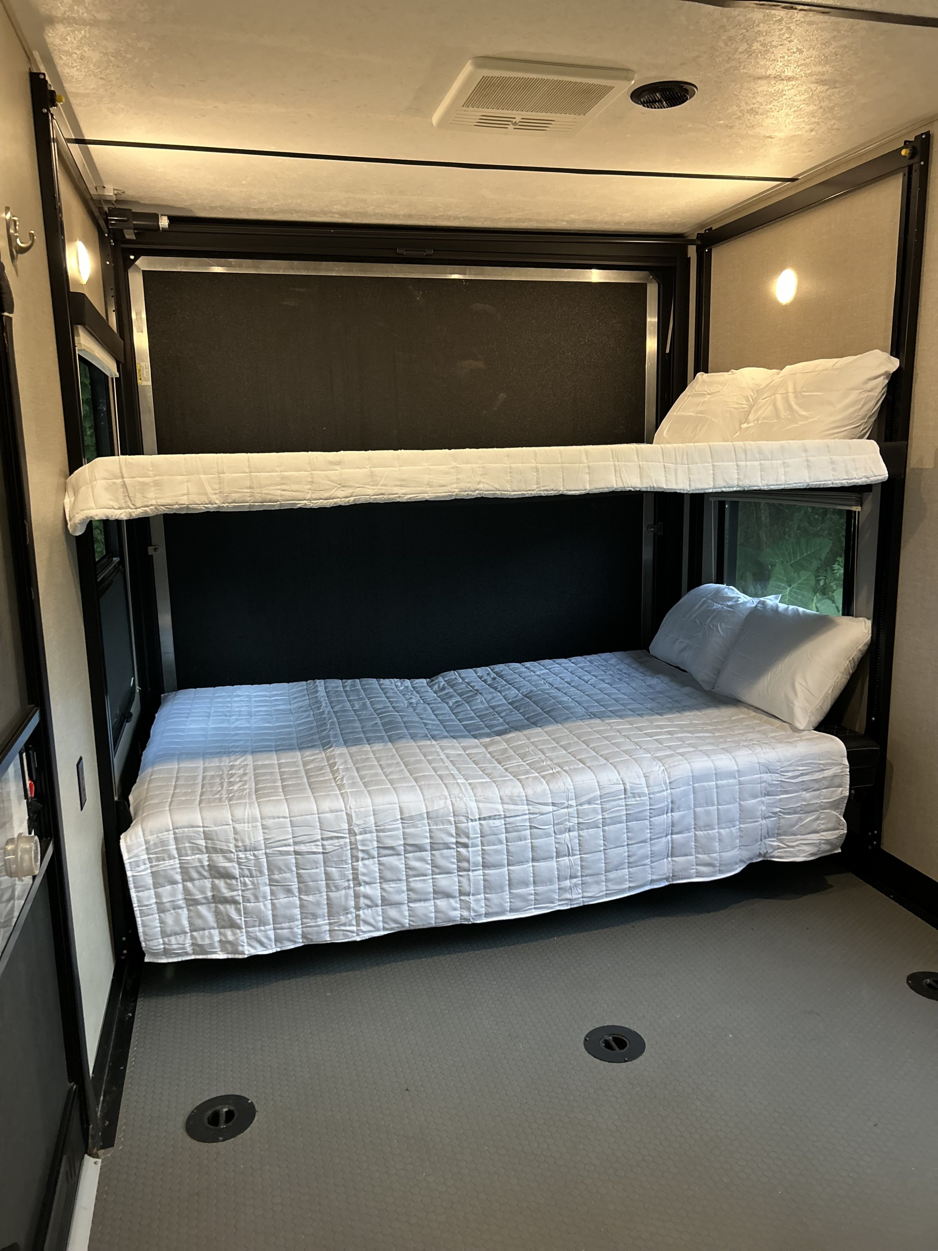 RV rental interior showing two made-up bunk beds and durable, textured flooring. Ready for your next adventure.. Keystone Impact 2018