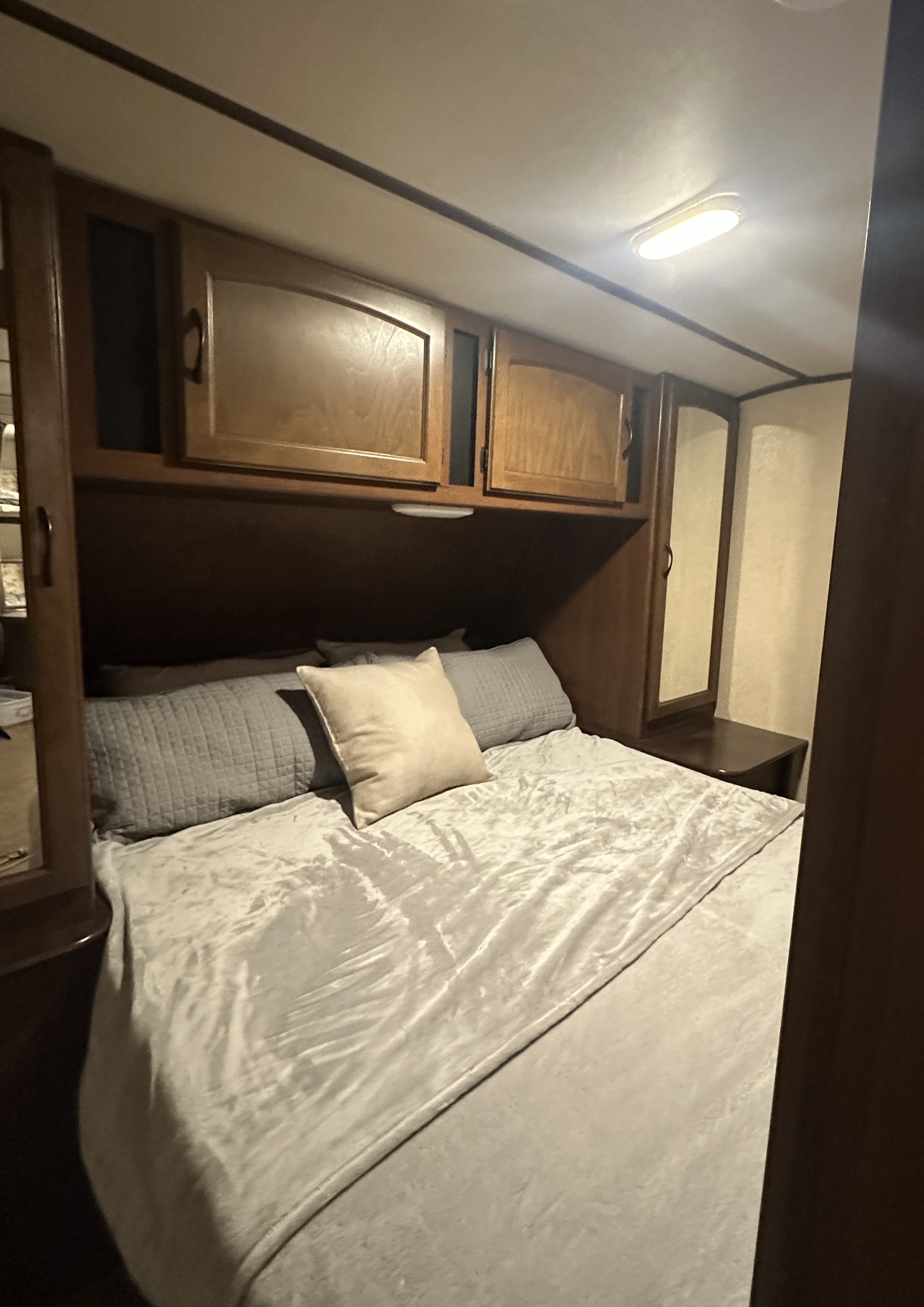 RV rental: inviting bedroom with a comfortable bed, overhead wooden cabinets, and bright ceiling light for cozy travel.. Jayco White Hawk Ultra Lite 2015