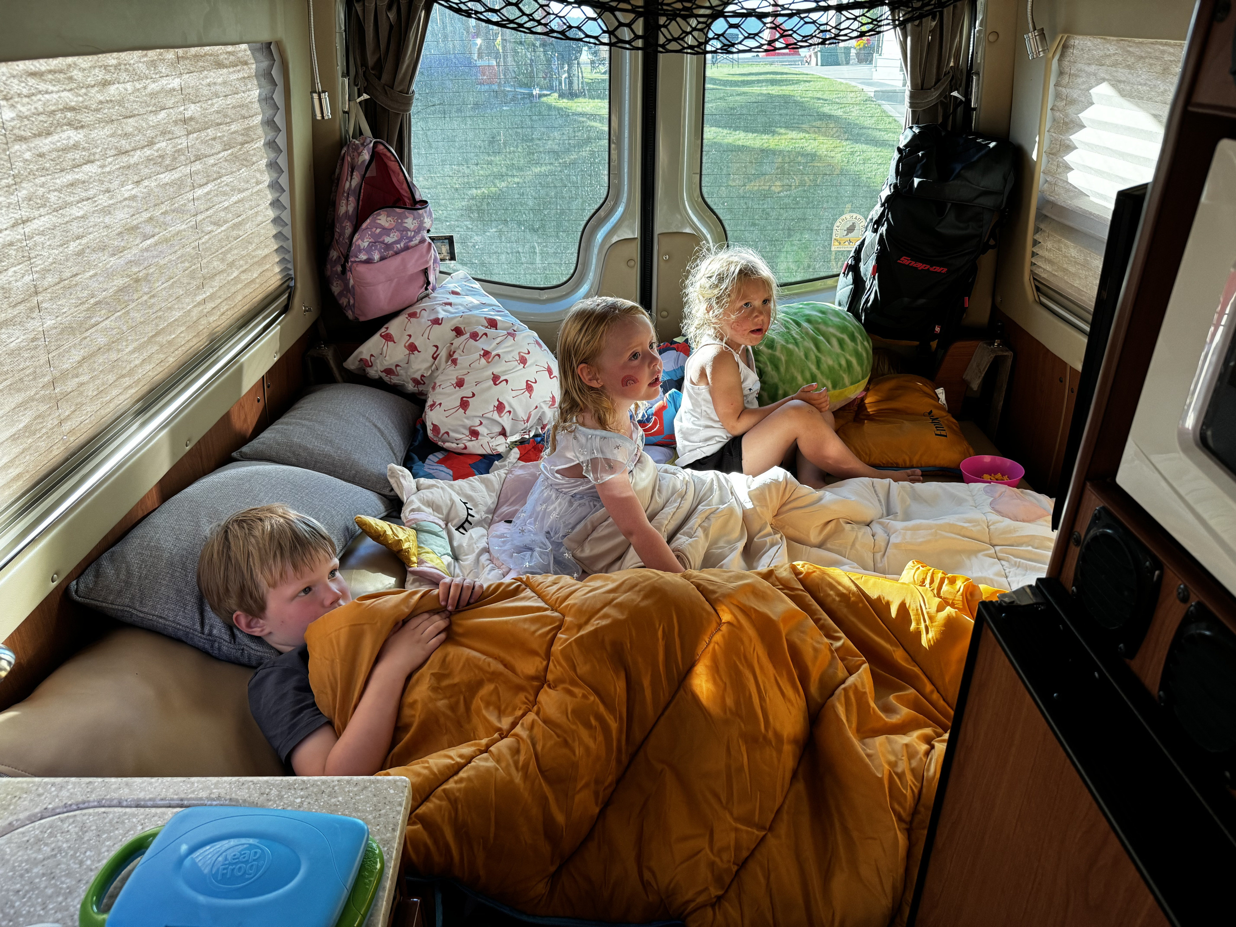 Kids enjoying an RV rental adventure. Three children cozy inside a camper van, perfect for family travel and camping.. Sportsmobile Regular Body 2013