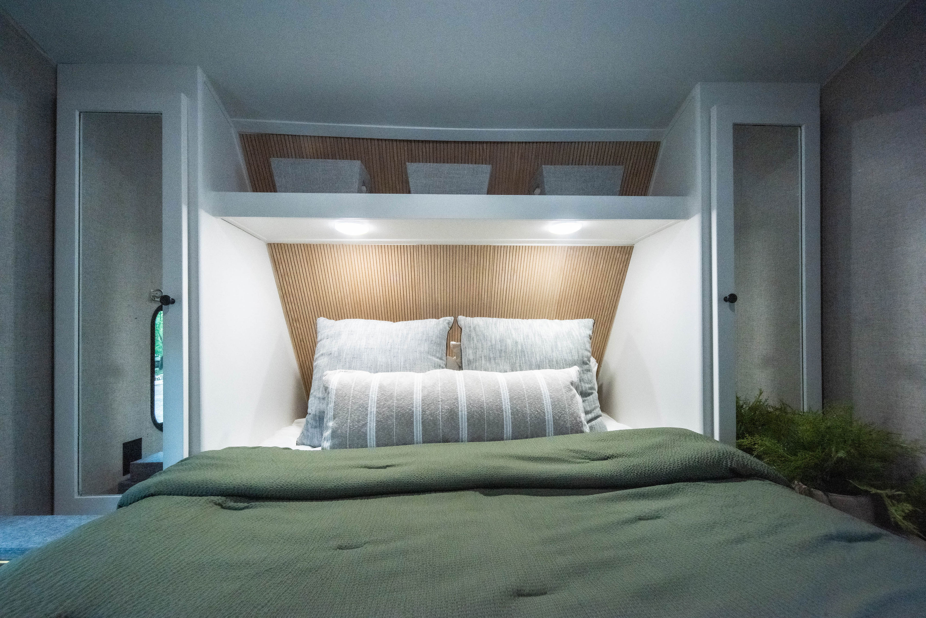 Cozy RV rental bedroom with a bed, wooden slatted headboard with lighting, and integrated storage.. Aspen Trail Aspen Trail Trailer 2019