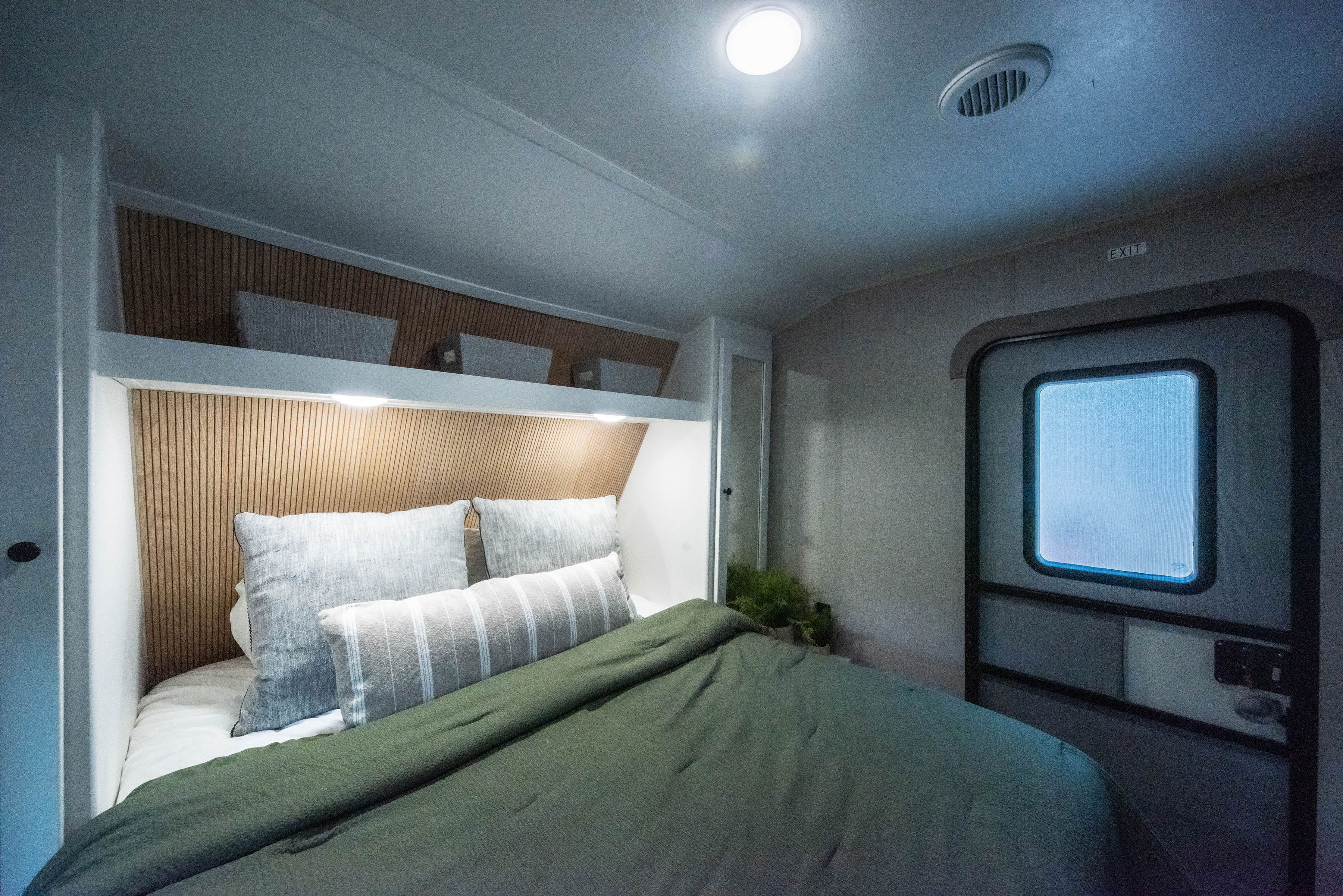 Cozy RV rental bedroom featuring a comfy bed, wood headboard, and smart overhead storage.. Aspen Trail Aspen Trail Trailer 2019