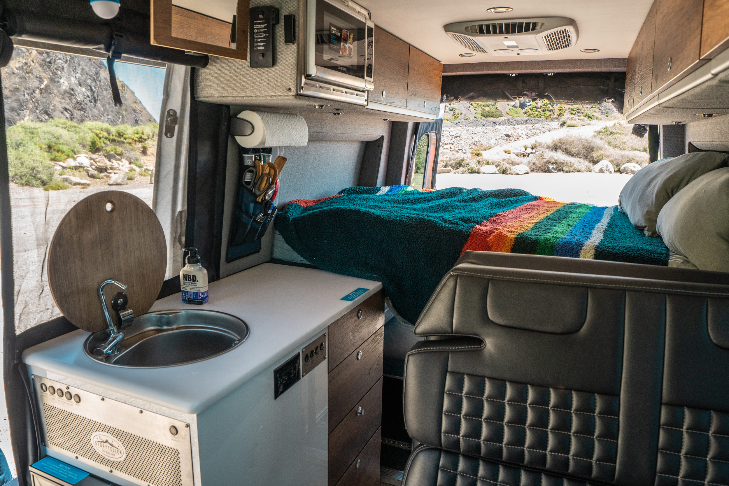 Explore this Storyteller Overland RV rental's well-appointed interior with a kitchen, comfy bed, and mountain views.. Storyteller Overland Storyteller Overland Class B 2022