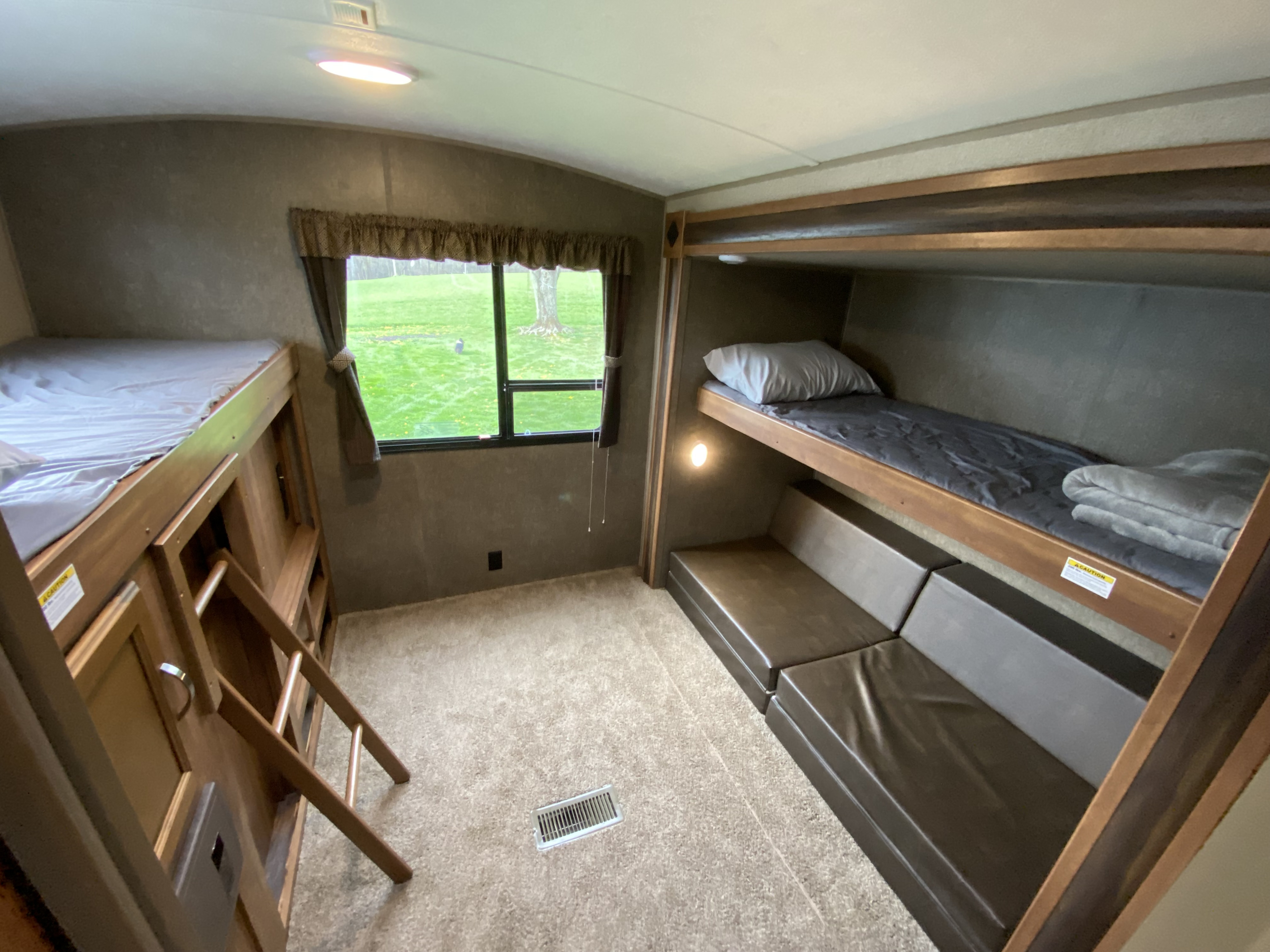 RV rental: Bright bunk room featuring two sets of bunks, a window with outdoor view, and convertible seating.. Keystone RV Springdale 2017