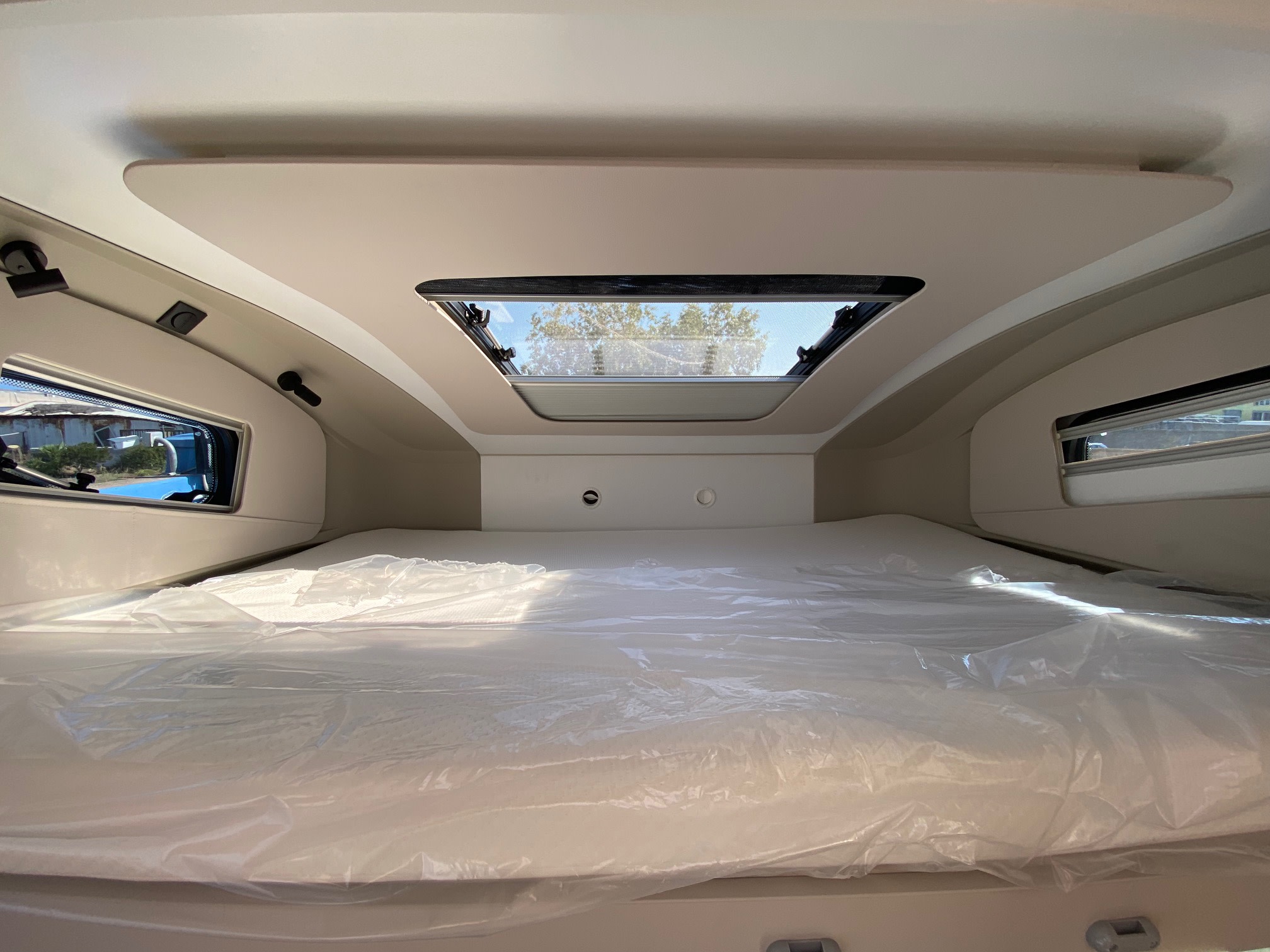 Bright and inviting RV rental interior, showcasing a fresh bed under a skylight. Ideal for comfortable camper adventures.. Adria Coral XL Axess 600 DP 2025