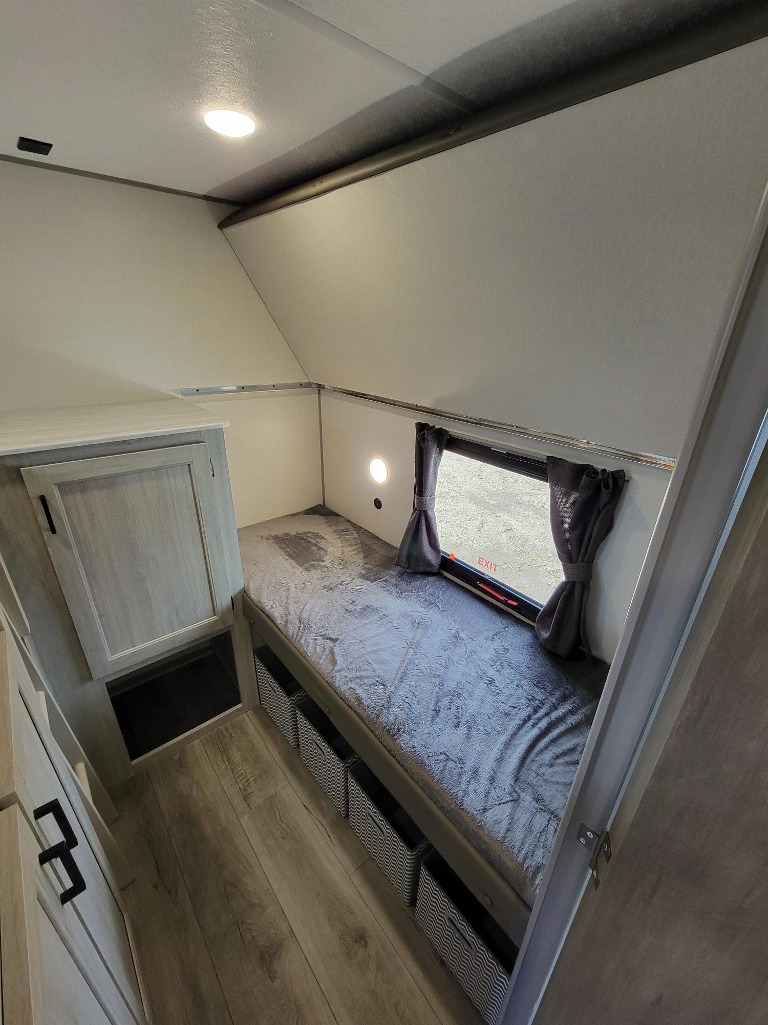 RV rental's compact bedroom with a comfy bed, window, light, and clever under-bed storage baskets. Ideal for travel.. Coachmen Catalina 2025