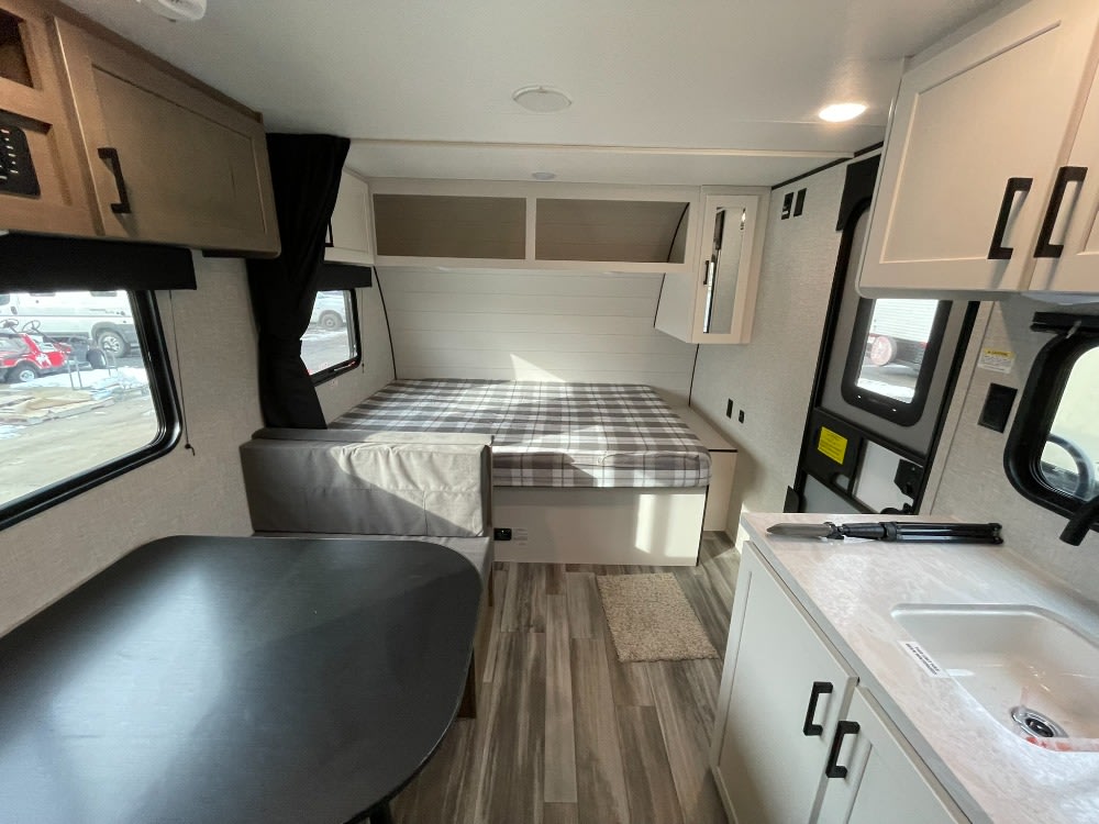 Compact RV rental interior featuring a cozy bed, dining area, and kitchen with sink and cabinets. Ready for travel.. Jayco Jay Flight SLX 175BH 2025