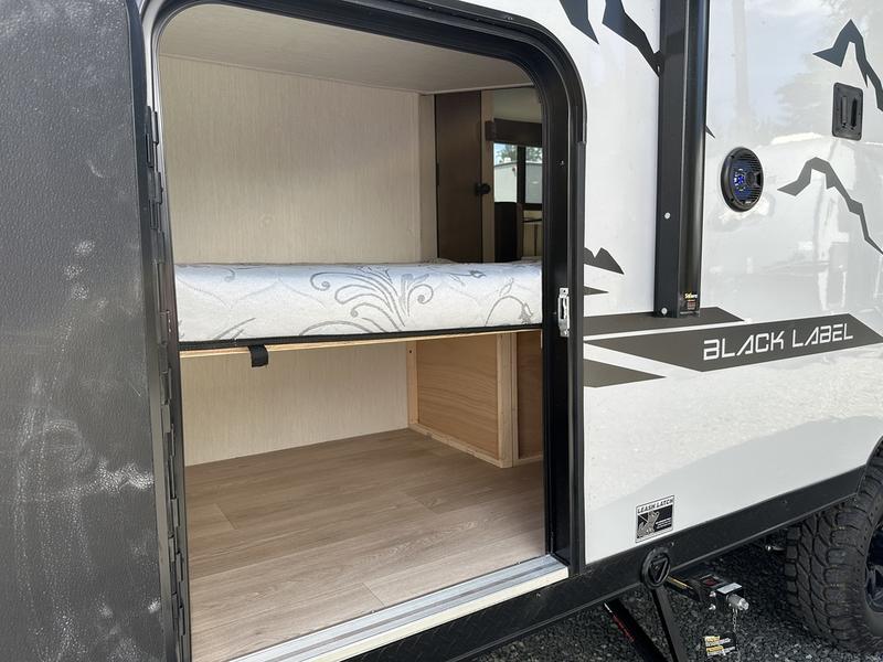 Explore this RV rental's interior: a cozy bunk bed above spacious storage. Perfect for compact adventures.. Forest River Cherokee Black Label 2025