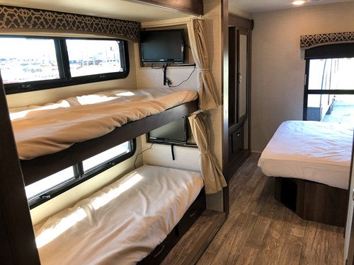 RV rental interior: A spacious camper featuring bunk beds with individual TVs, and a separate master bed area.. Jayco Alante 2018
