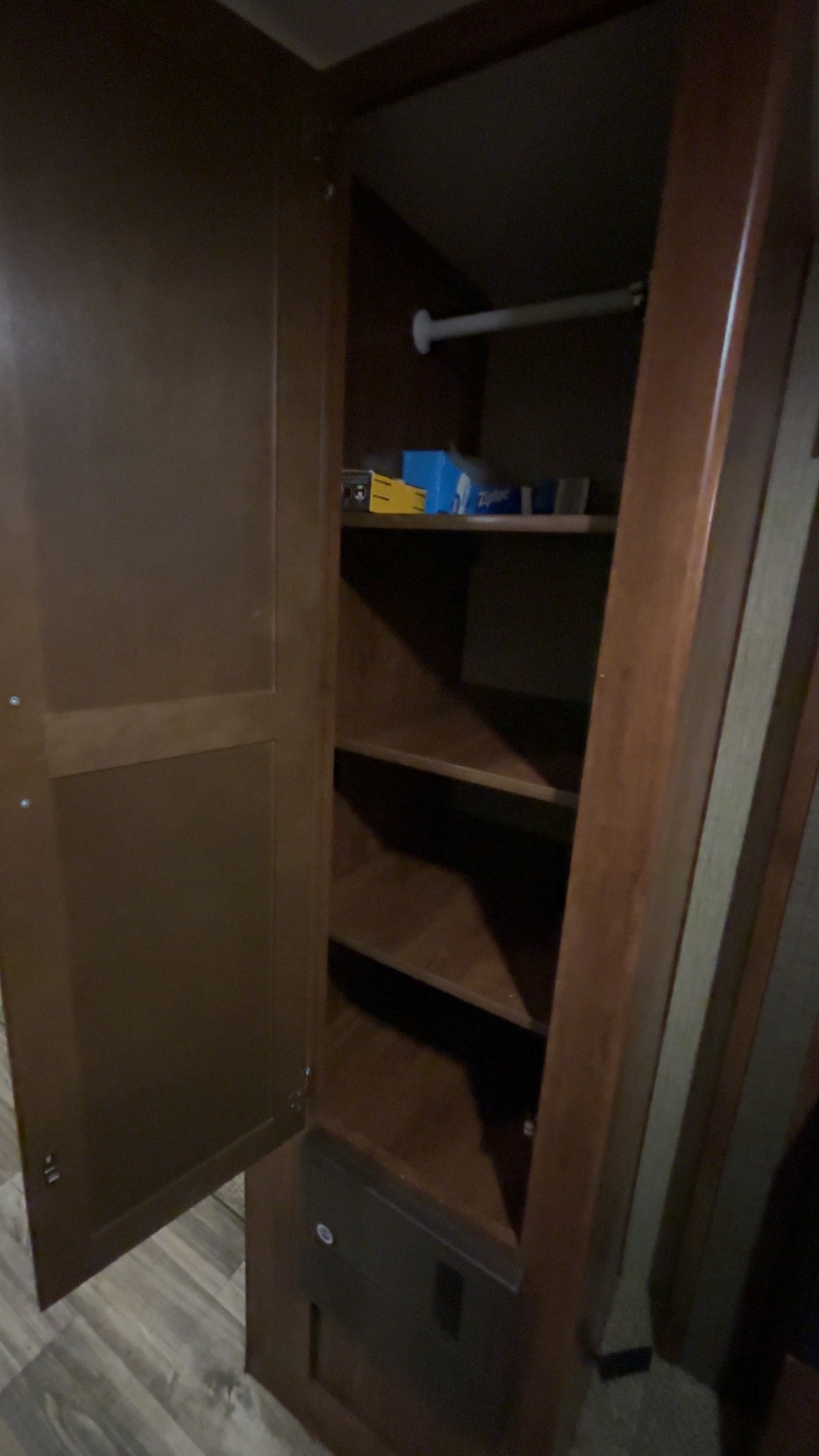 Open wooden closet with shelves, hanging rod, and electrical panel, ideal for an RV rental's storage needs.. Keystone RV Passport Grand Touring 2017