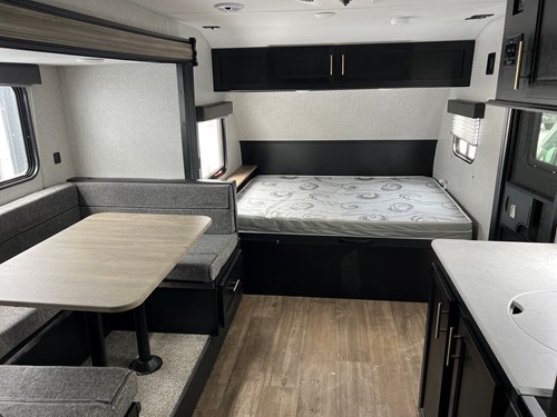 Spacious RV rental interior featuring a cozy dinette, comfortable bed, and compact kitchen area for your adventures.. Cherokee Wolf Pup 17JG 2022