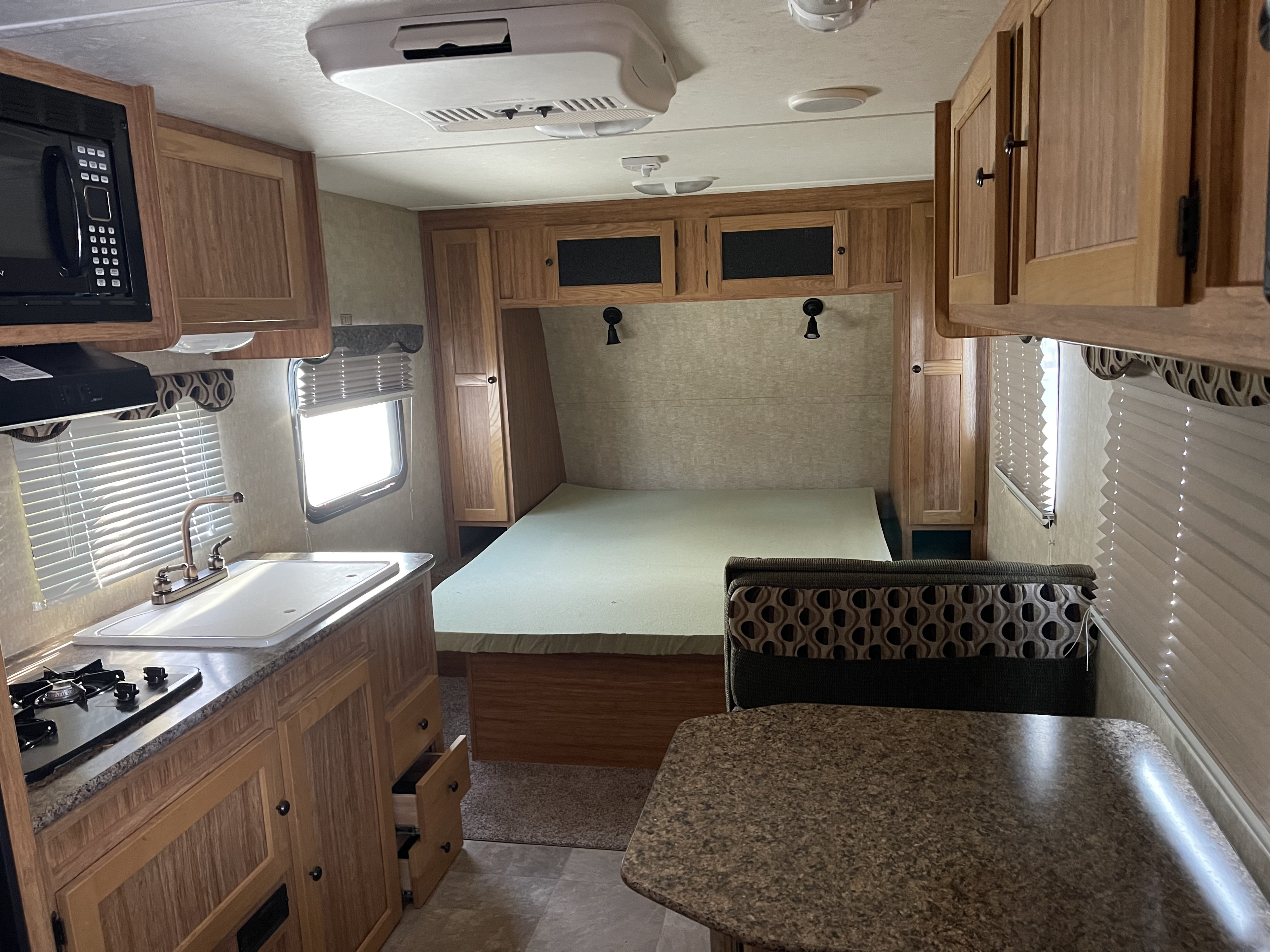 Spacious RV rental interior with kitchen, bed, and dinette, offering comfort for your next camper adventure.. Eco Camp Eco Camp Trailer 2014