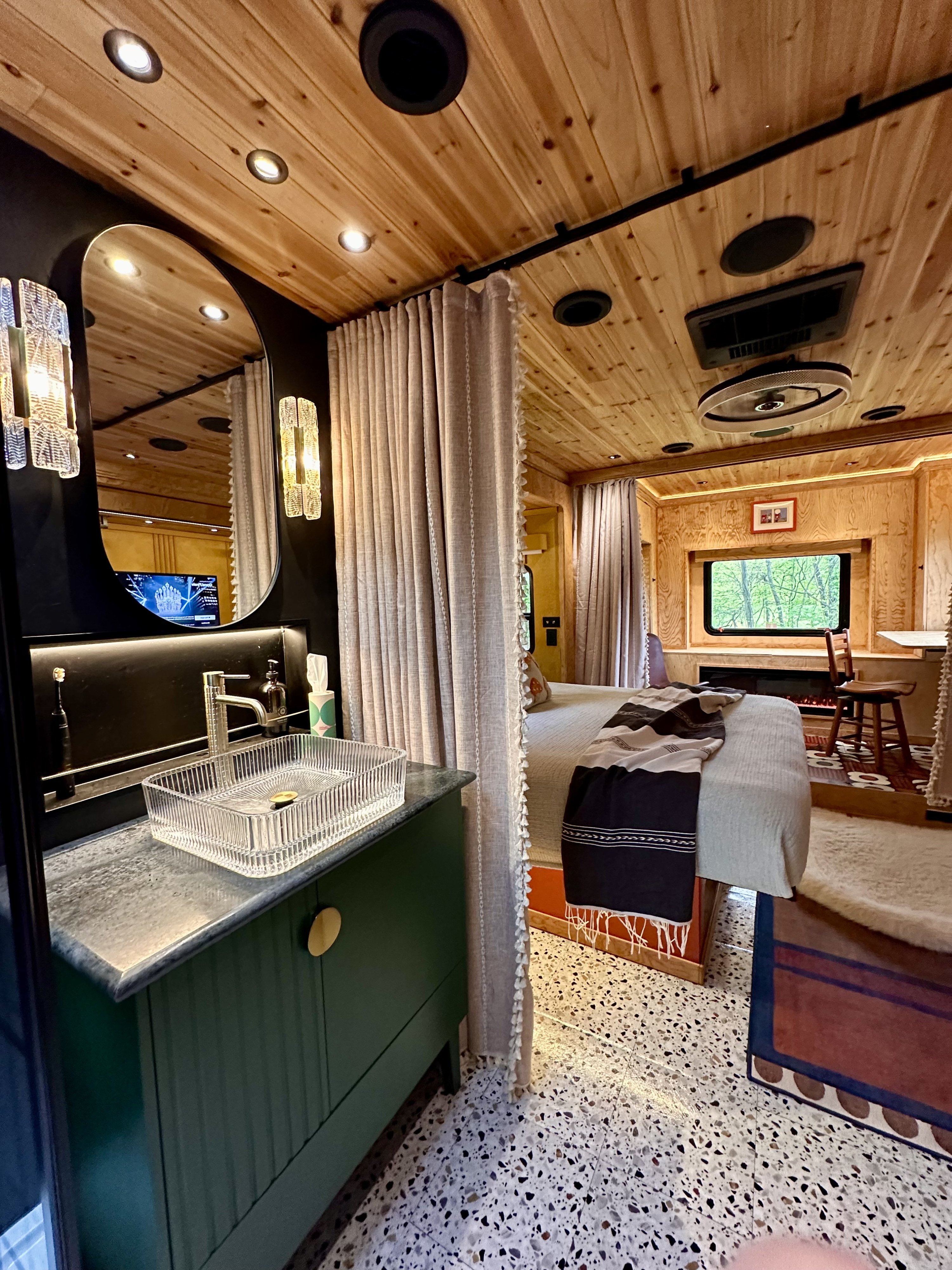 Modern RV rental interior, featuring a bath vanity, cozy bedroom, wood-paneled ceiling, and scenic window.. Safari Cheetah 2007
