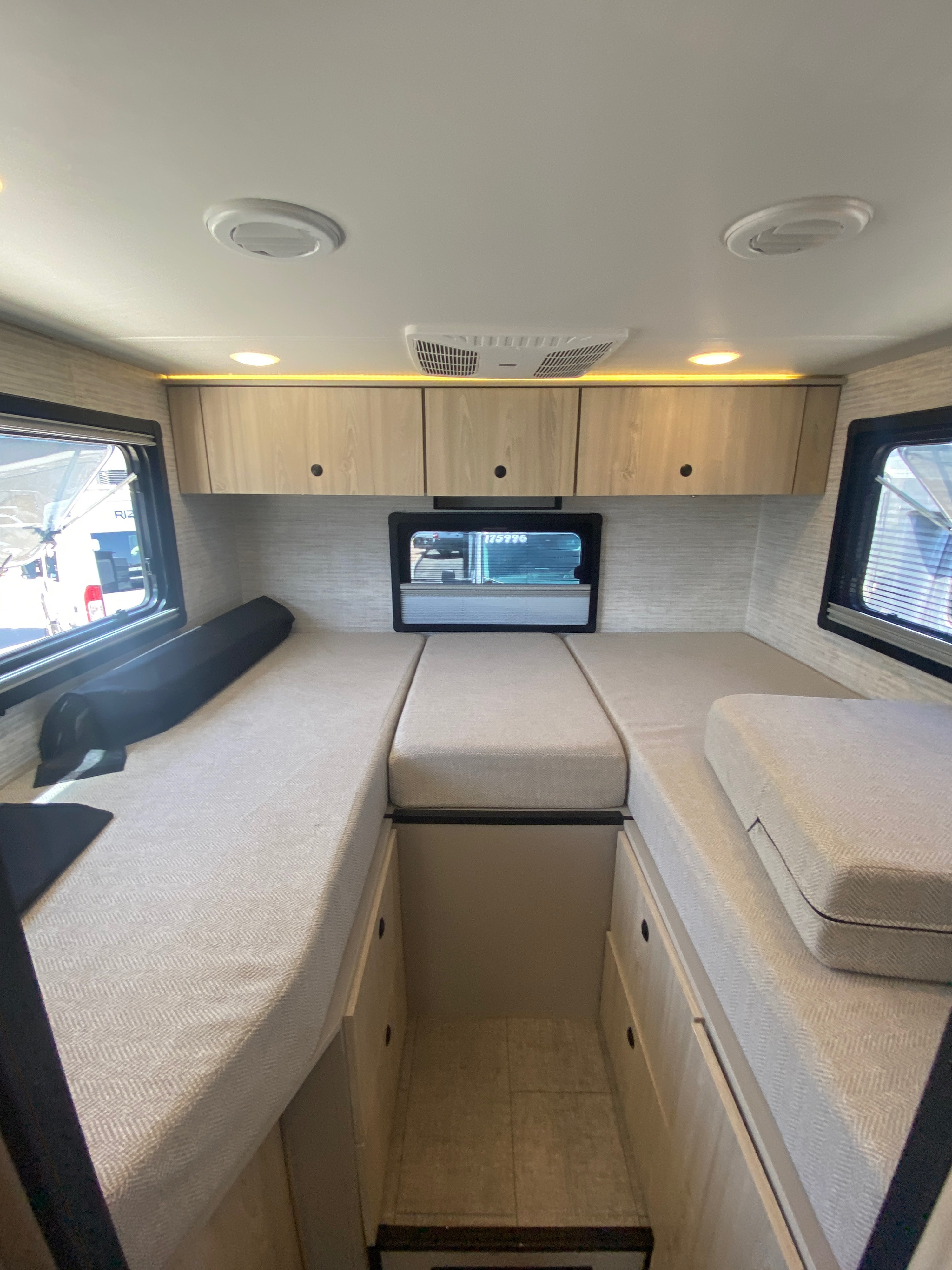 Inside an RV rental: modular beds, overhead storage, and side windows offer comfortable, compact living.. Entegra Condor 2025