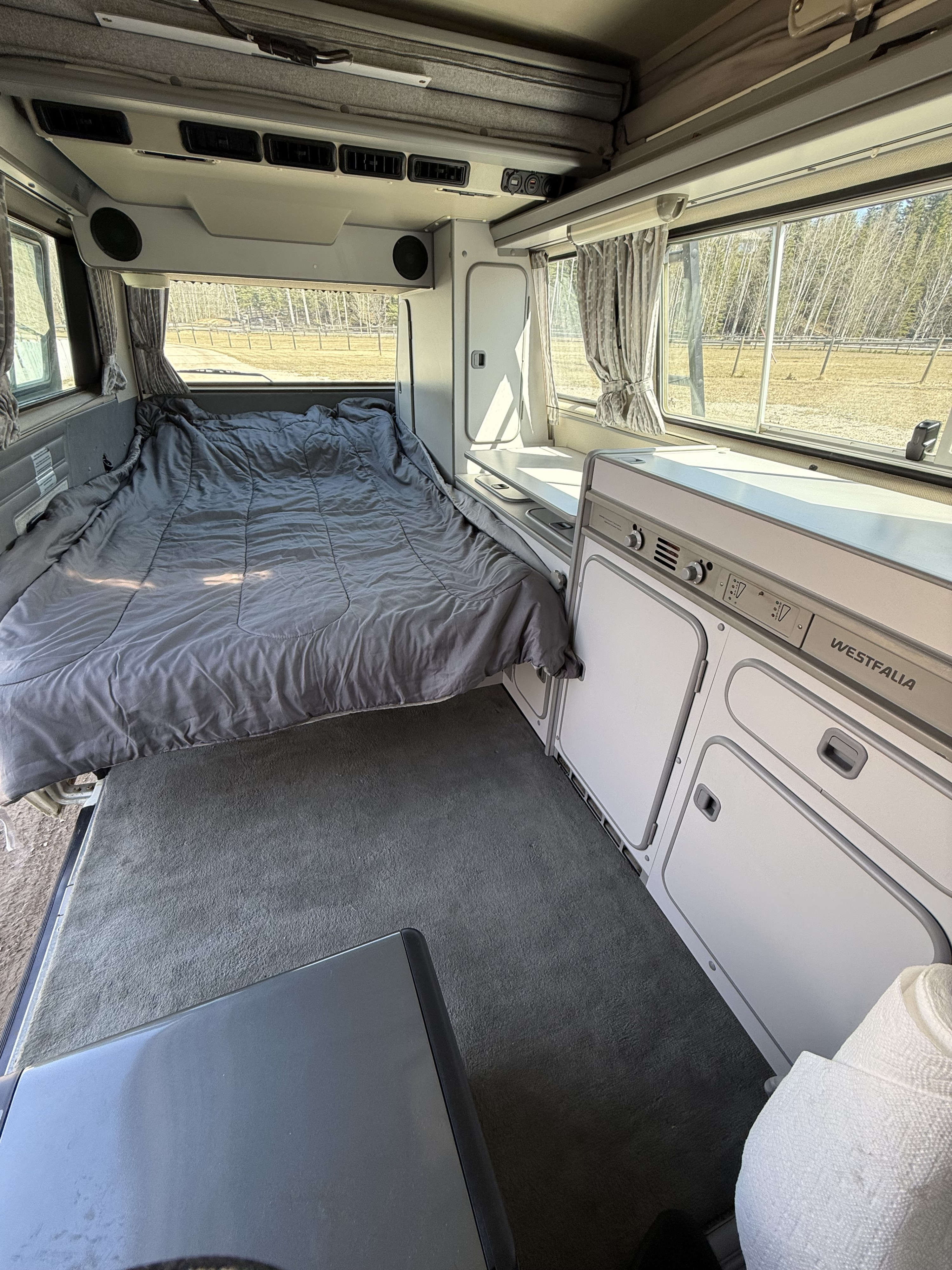 Westfalia RV rental interior: a comfy bed, integrated kitchen, and pop-top roof.. Volkswagen T3 1991