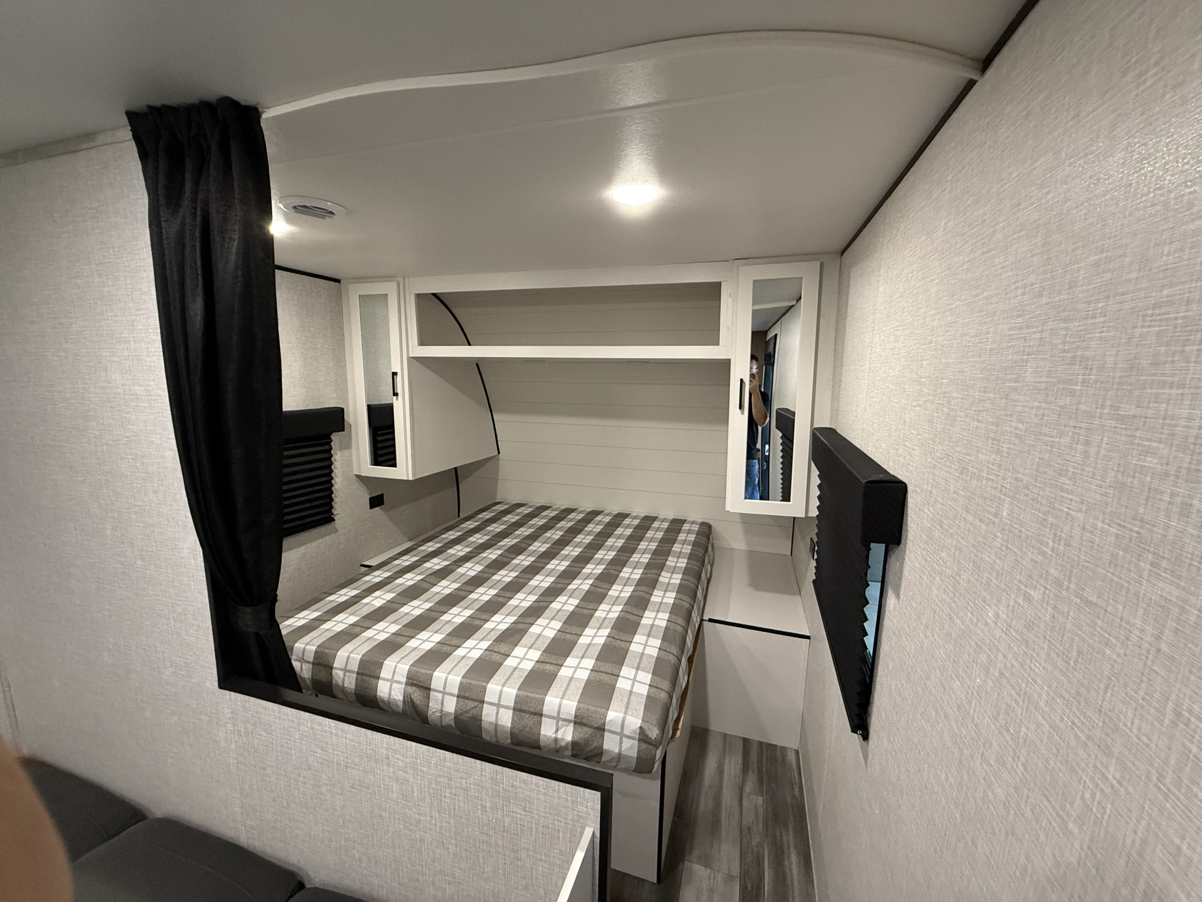 RV rental bedroom: A comfortable queen bed with plaid bedding, overhead cabinets, and bright, textured walls in a compact space.. Jayco Jay Flight STX 260BHW 2025