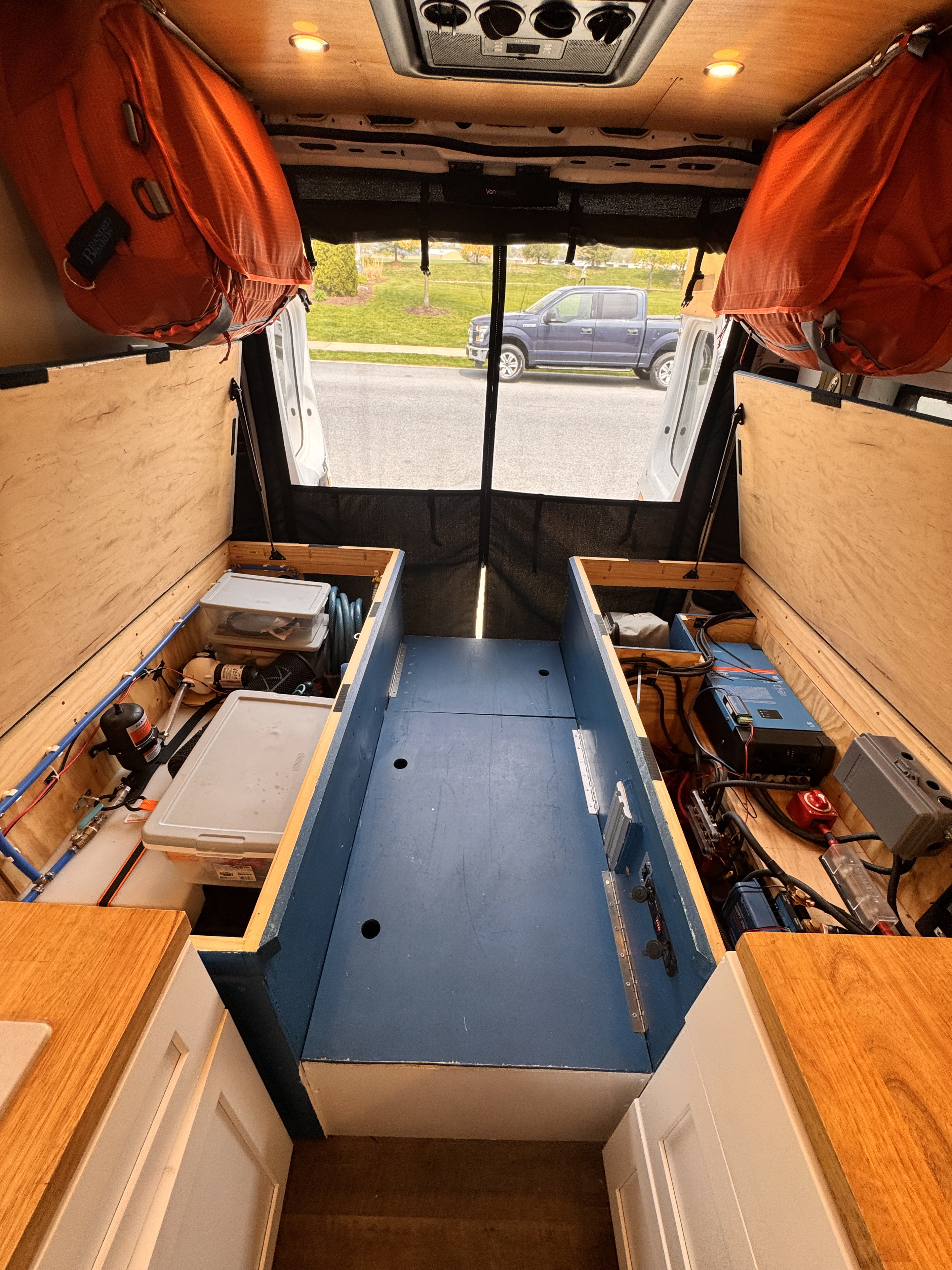 Custom camper van interior for RV rental: shows rear view, dual storage/bed boxes, and essential plumbing/electrical systems.. Ram Promaster 2500 2016