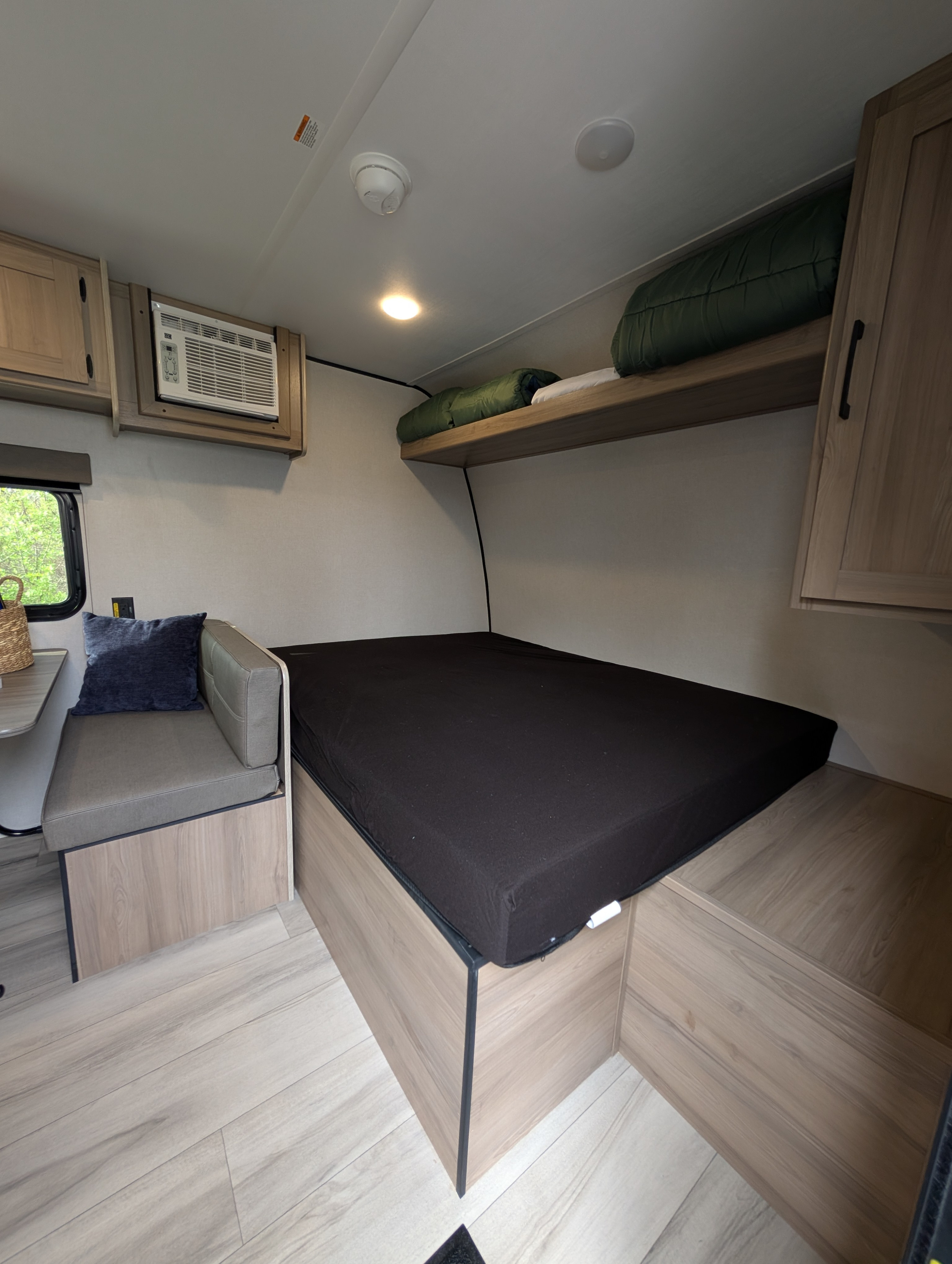 Cozy RV rental interior with bed, dinette, and AC. Perfect compact camper for your next adventure.. Keystone Coleman 2025