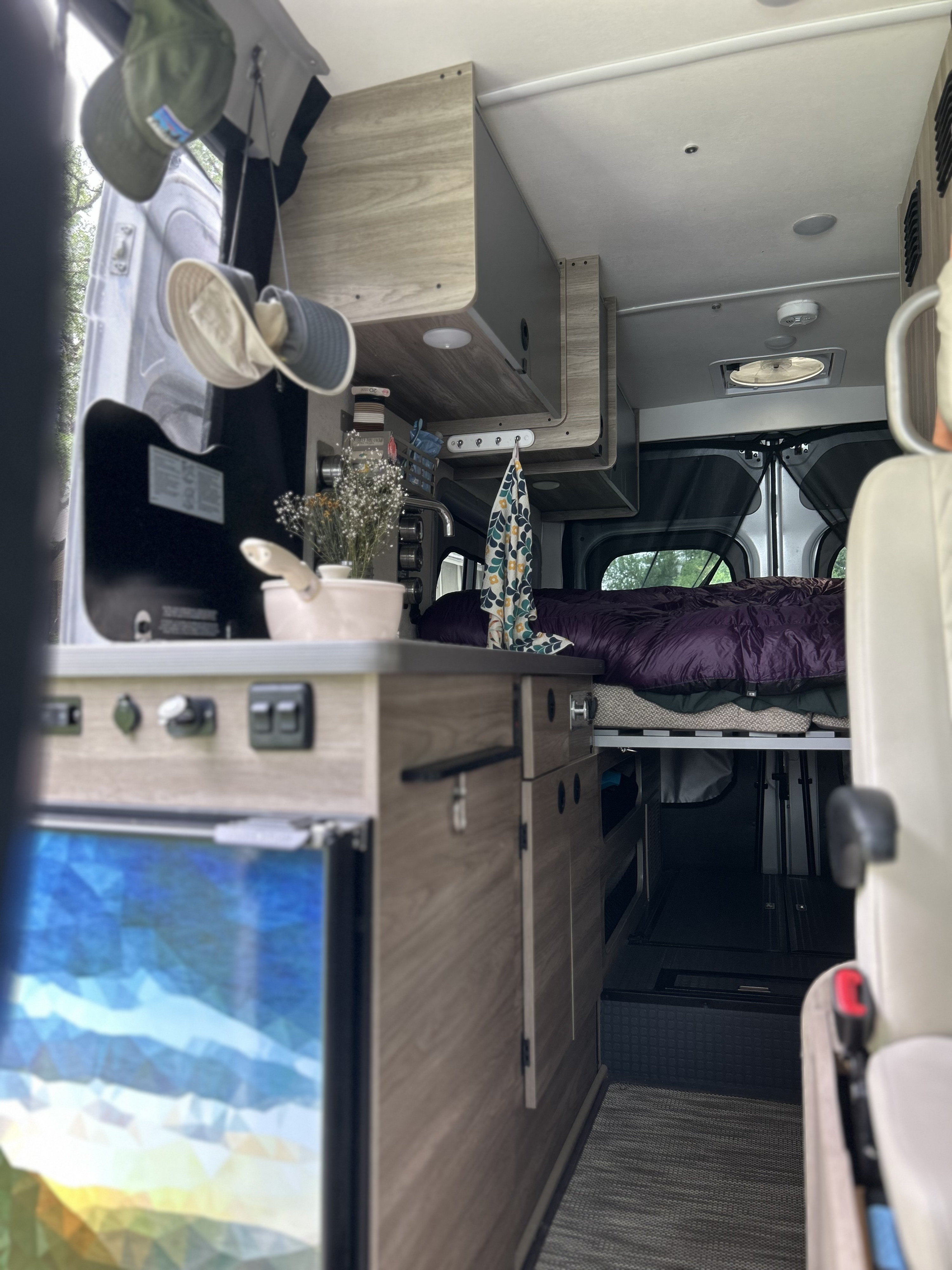 RV rental interior featuring a compact kitchen, bed, and smart storage solutions for cozy travels.. Winnebago Solis National Park Foundation 2023