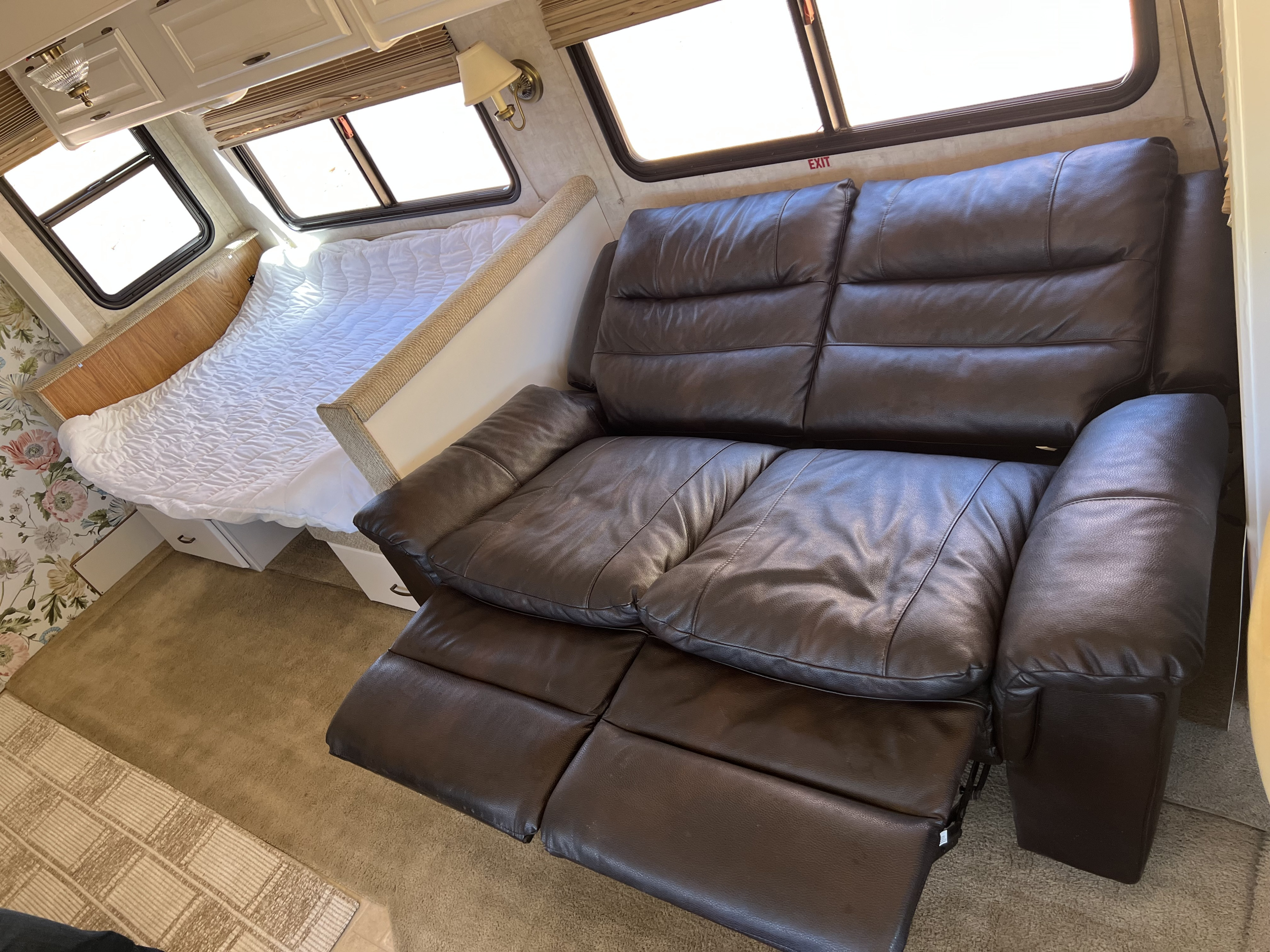 Comfortable RV rental interior: features a bed, reclining leather sofa, & windows for a cozy travel experience.. Fleetwood Bounder 2005