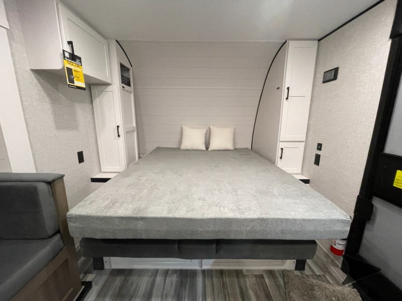 Relax in this RV rental's cozy bedroom. Features a large bed, ample storage cabinets, and textured wall design.. JAYCO JAY FLIGHT SLX 197MBW BAJA-G 2025