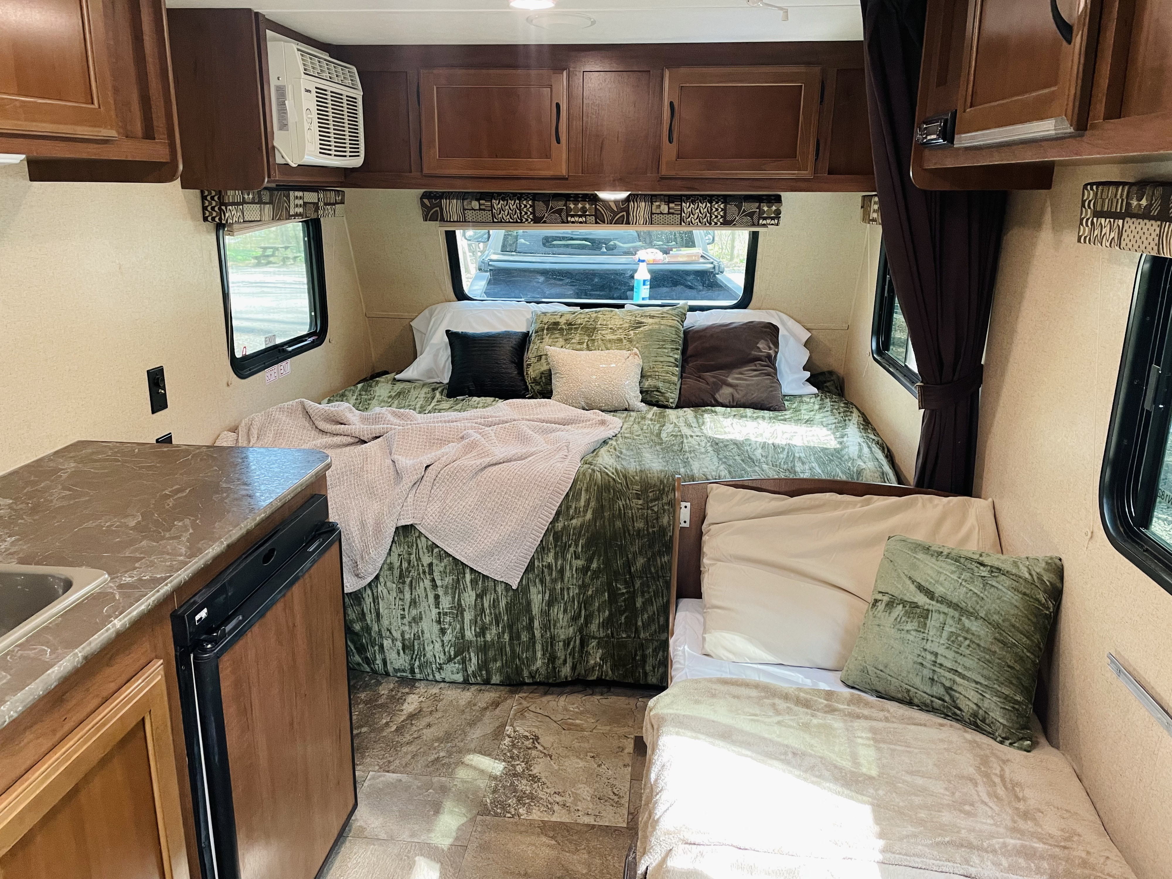Cozy rv rental interior with a bed, kitchen counter, fridge, AC, and storage. Perfect for your next trip!. Jayco Jay Flight 2016