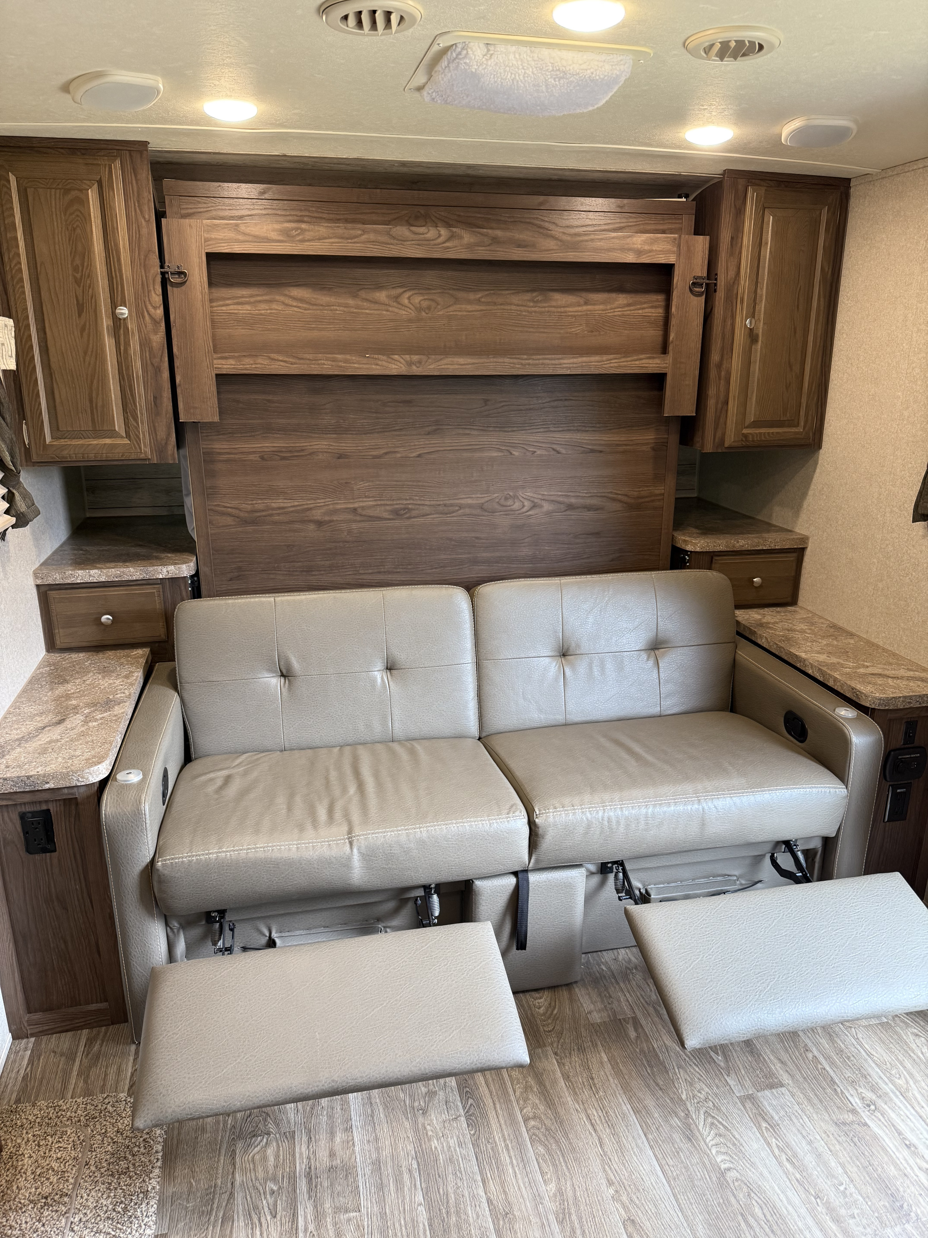 RV rental interior with cozy theater seating, featuring extended recliners, built-in storage, and charging ports.. Forest River Flagstaff Micro Lite 2019