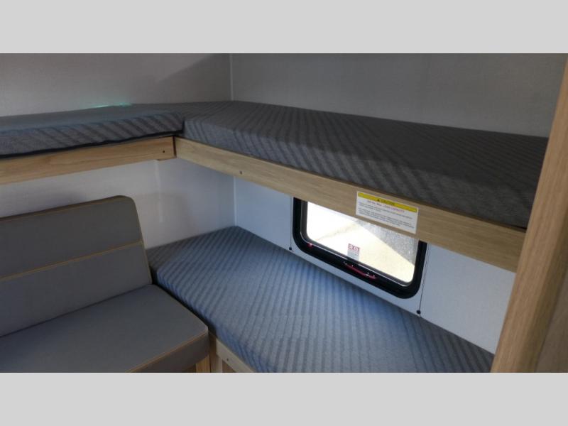 RV rental interior: multiple bunk beds with gray mattresses and a cozy seating area. Ideal for travel and rest.. Avenir 32bh 2025