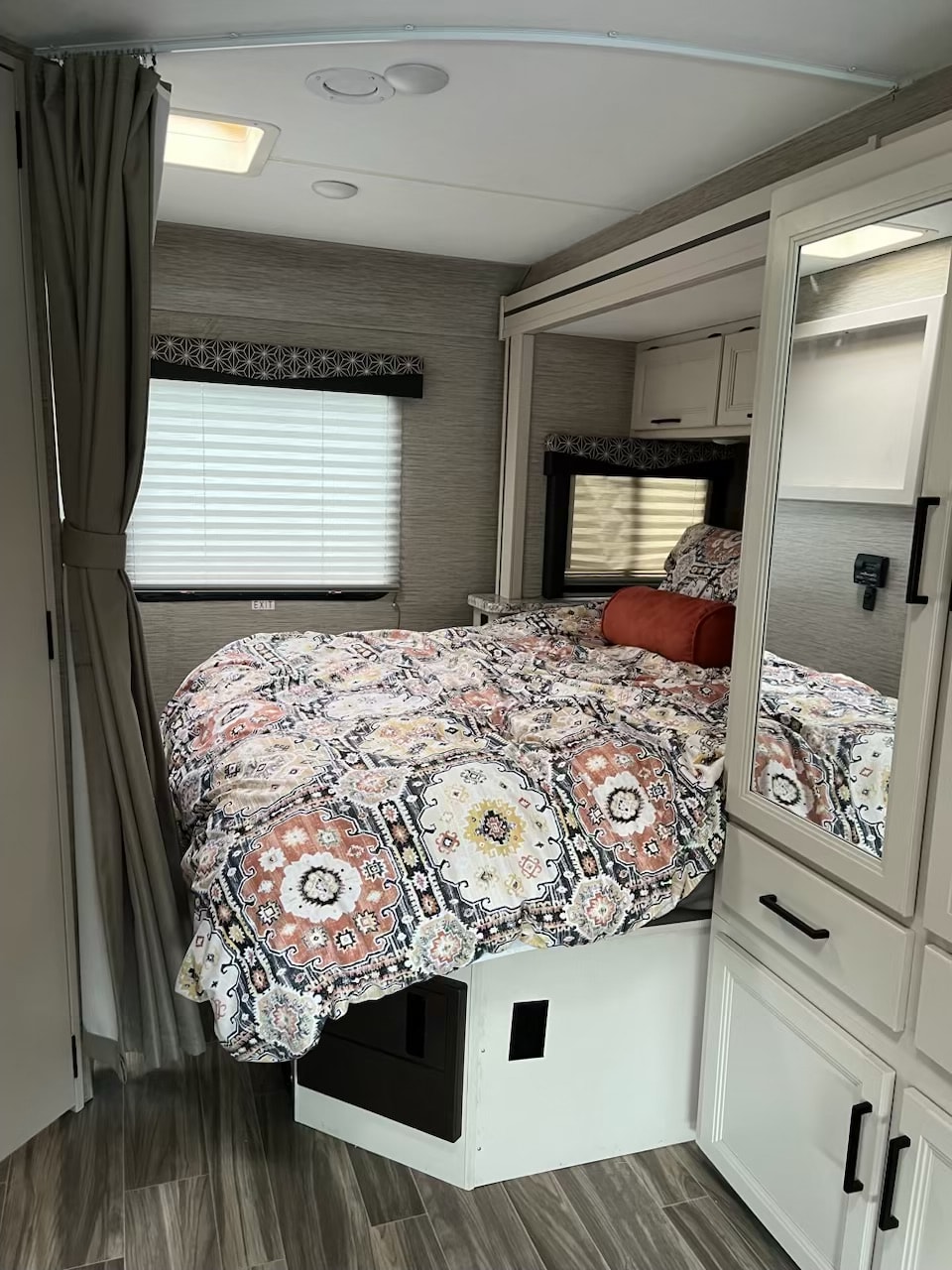 Step inside this cozy RV rental bedroom. Features a comfy bed with vibrant comforter, windows with blinds, and ample storage.. Thor Freedom Elite 2022