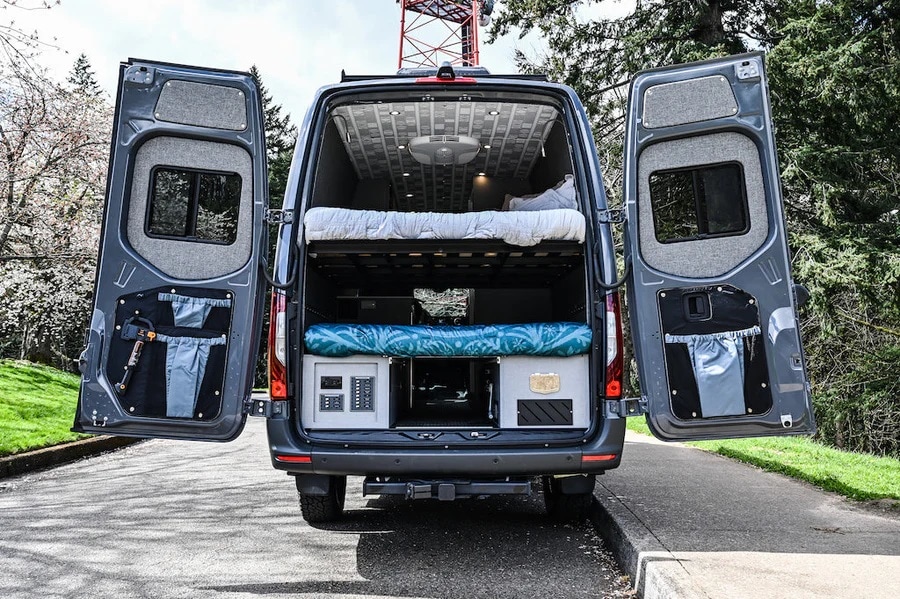 Rear view of custom rv rental van with open doors, revealing bunk beds, storage, and utility panel.. Mercedes-Benz Sprinter 2021