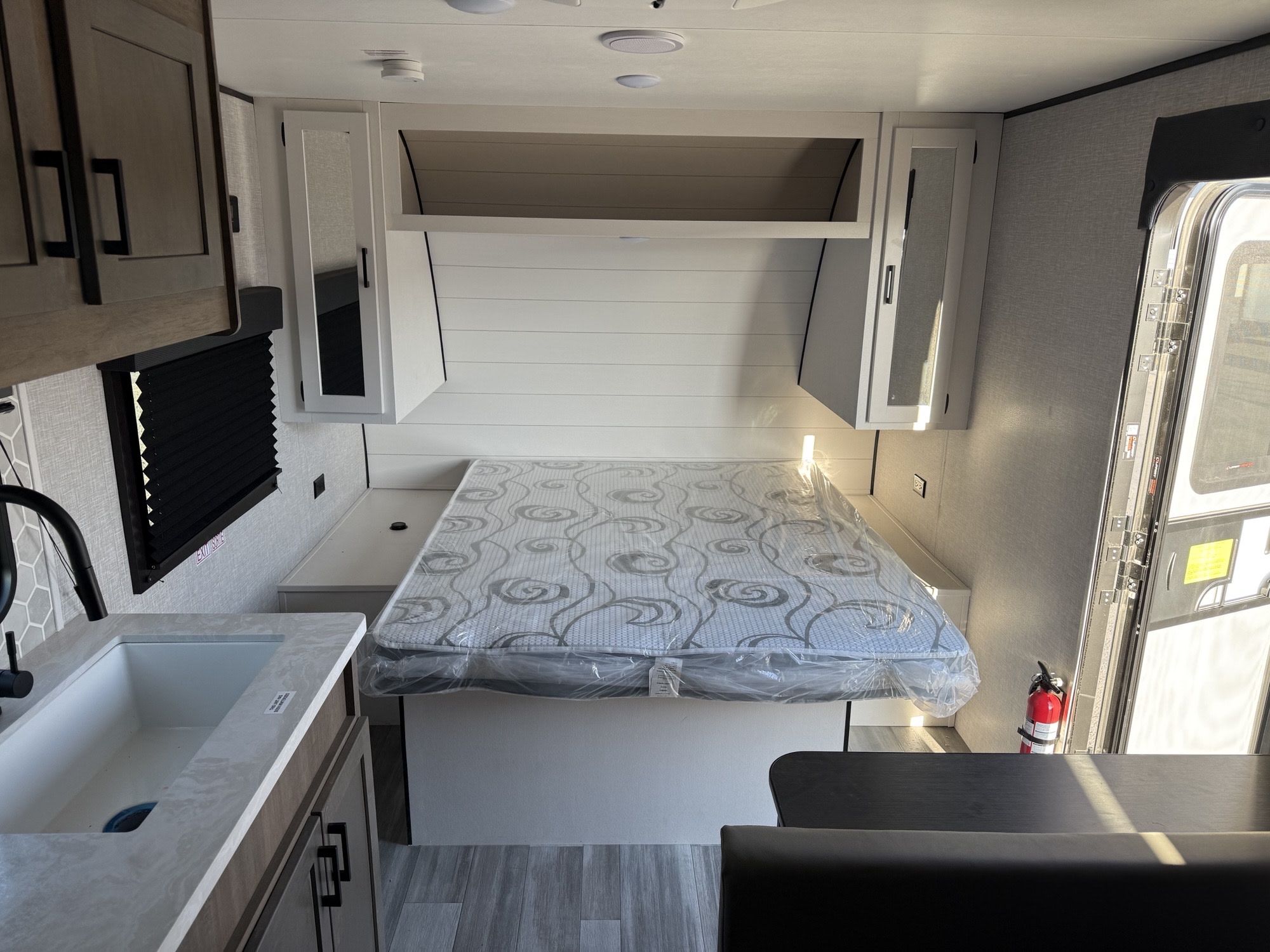 A compact RV rental interior features a new bed, kitchen sink, and dining area, ideal for adventures.. Starcraft Autumn Ridge 2024
