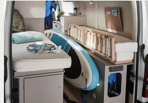 RV rental interior features smart storage: a comfy bed with snorkeling gear & a large paddleboard tucked below.. Burstner DELFIN C 621 LIMITED 2023