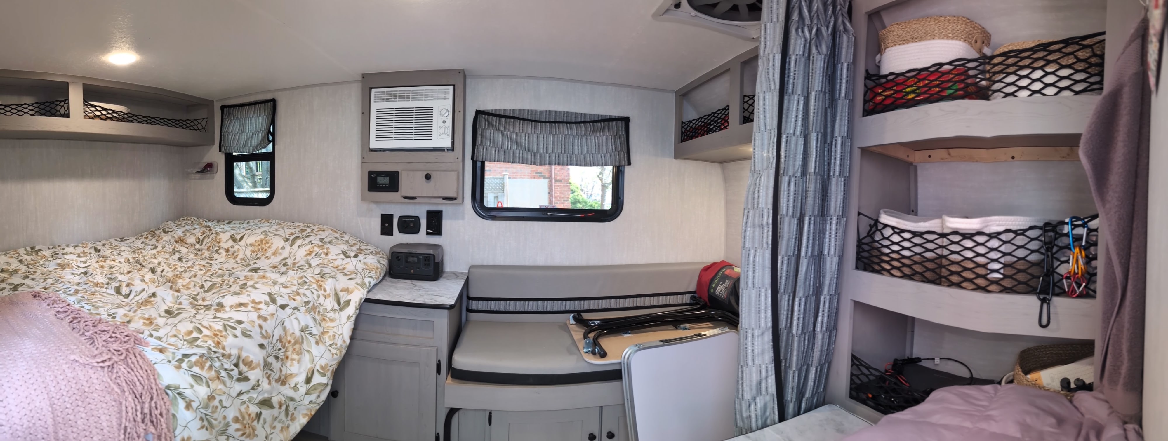 Comfortable RV rental interior: bed, dinette, AC, power station, and netted storage for travel.. Coachmen Viking 1200ROK 2025