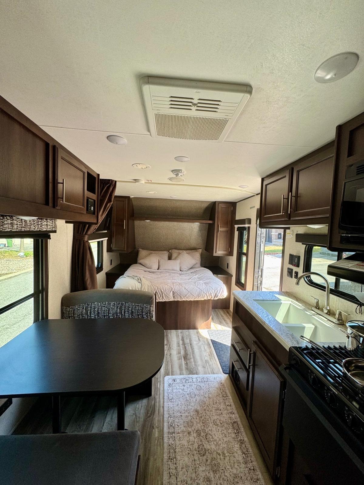 Cozy RV rental interior showcasing a bedroom, dining area, and full kitchen. Ideal for travel adventures.. Jayco Jay Flight SLX 2019
