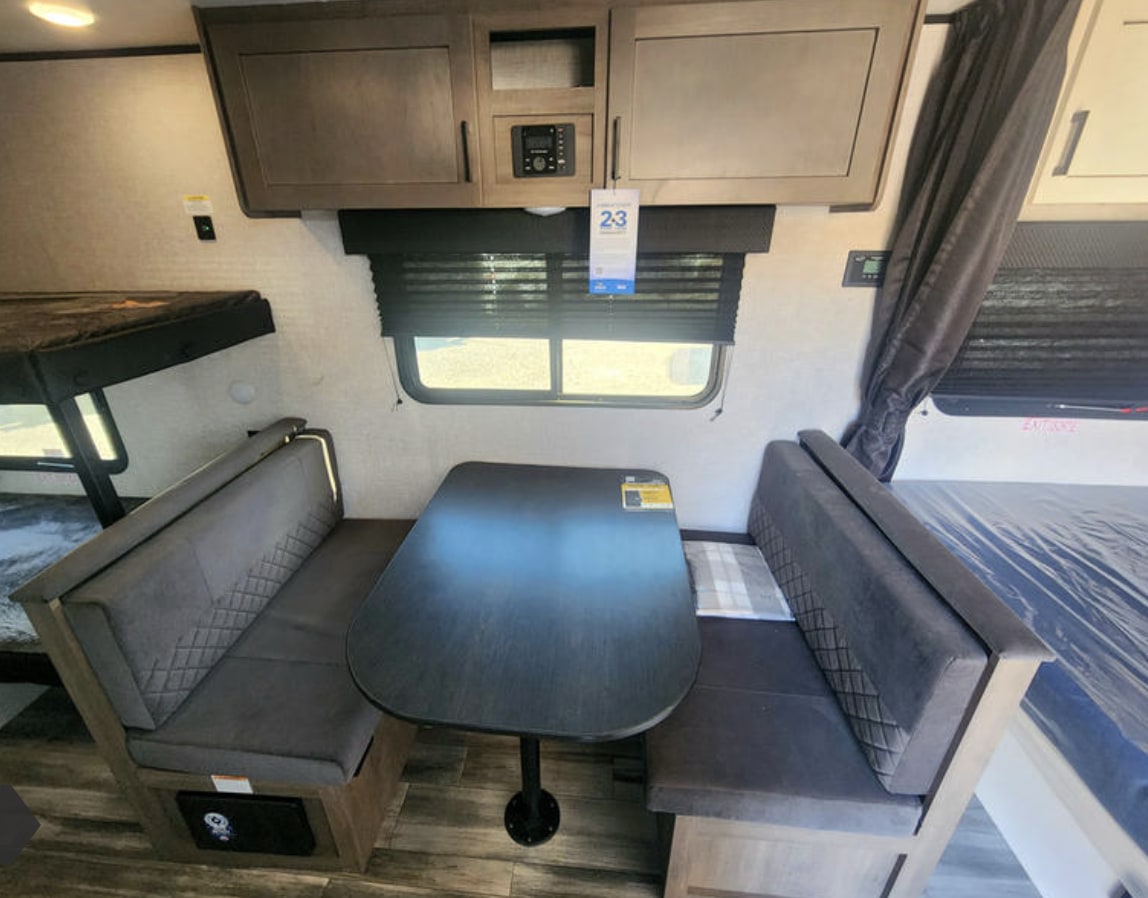 RV rental interior shows compact dining booth, bunk beds, and sleeping area. Efficient space for travelers.. Jayco Jay Flight SLX 2025