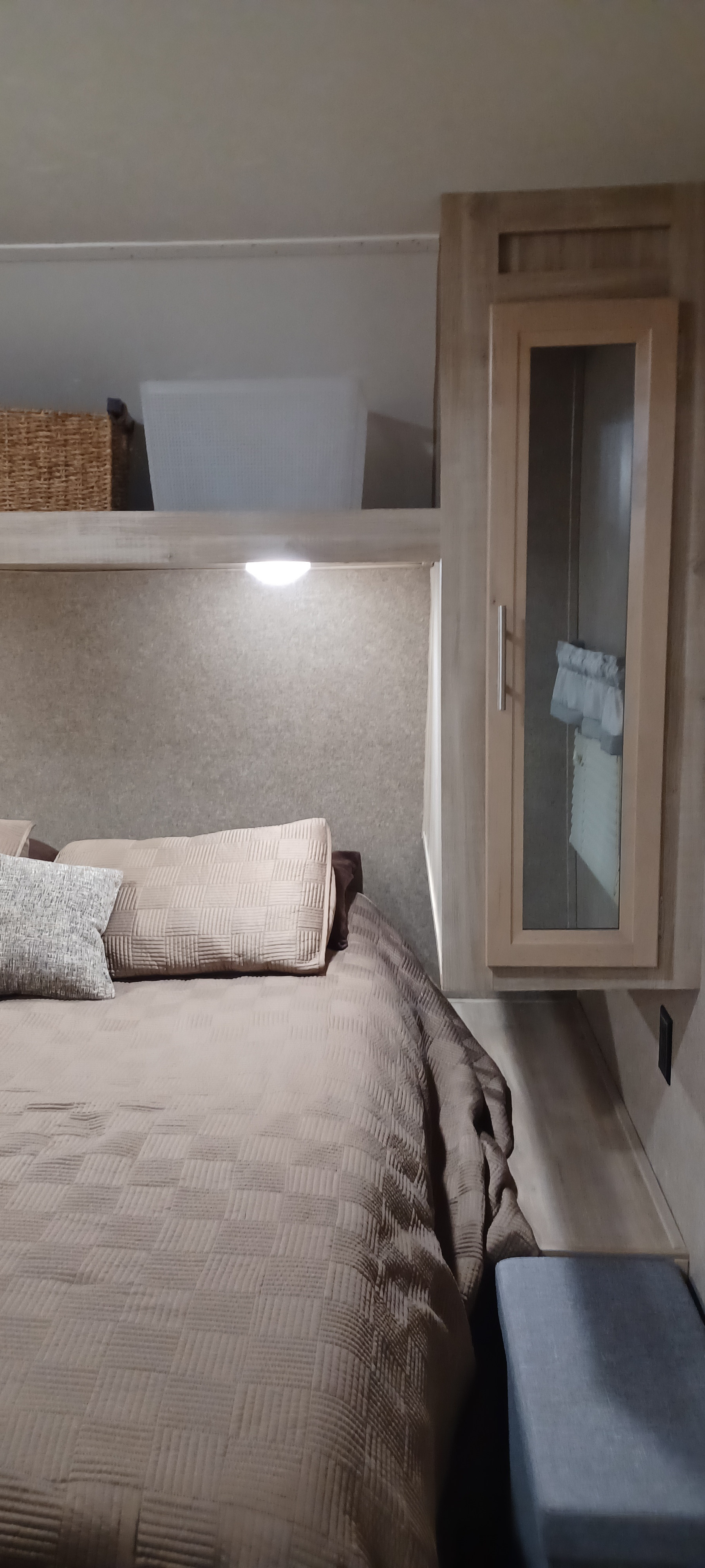 Compact RV rental bedroom features a neutral bed, overhead storage, and mirrored cabinet.. Forest River Coachmen Catalina SBX 2019