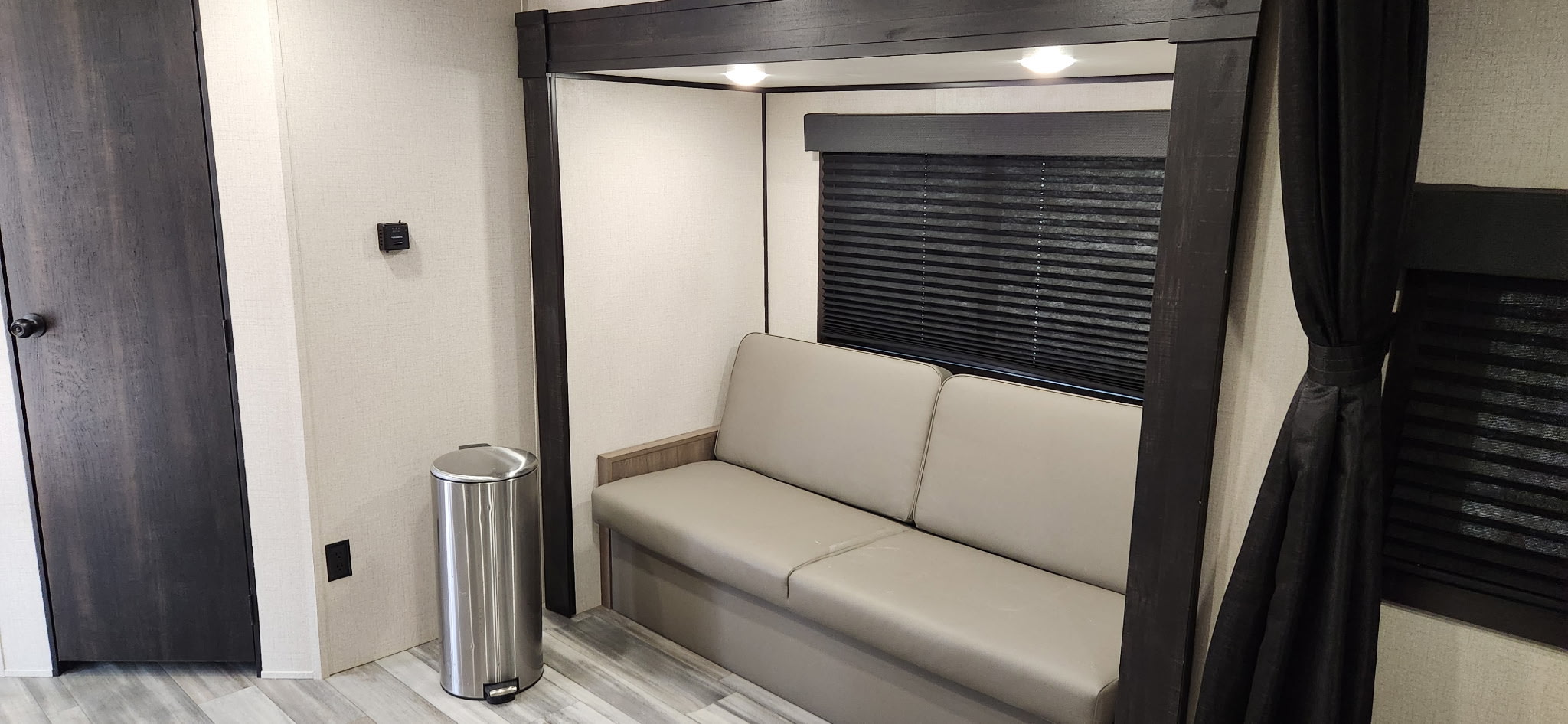 Compact RV rental living space featuring a comfortable sofa, window with blinds, and built-in bunk area. Perfect for travel comfort.. Highland Ridge RV Go Play 2024