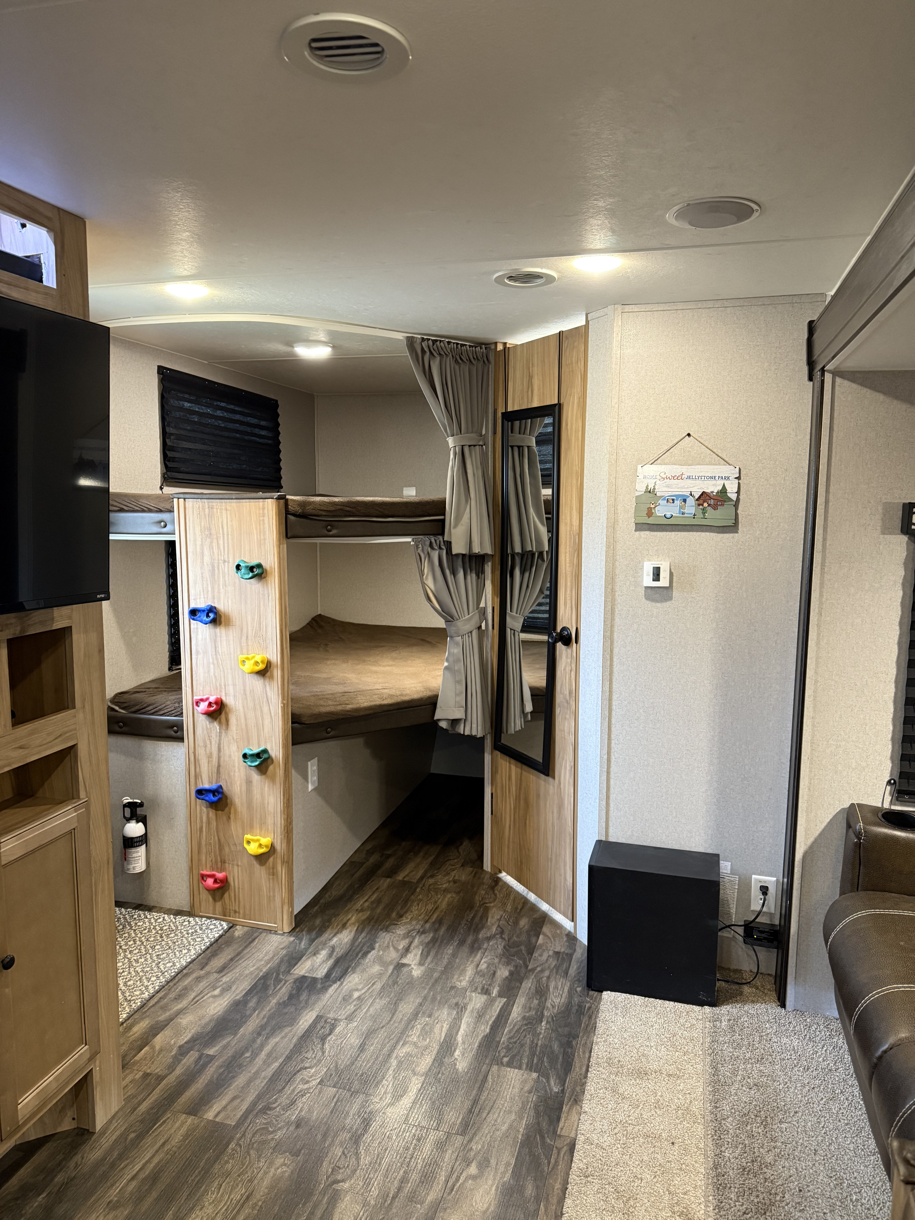 RV rental interior showing bunk beds with a fun climbing wall, TV, and wood-look flooring. Ideal for family adventures.. Coachmen Freedom express ultra light 2019