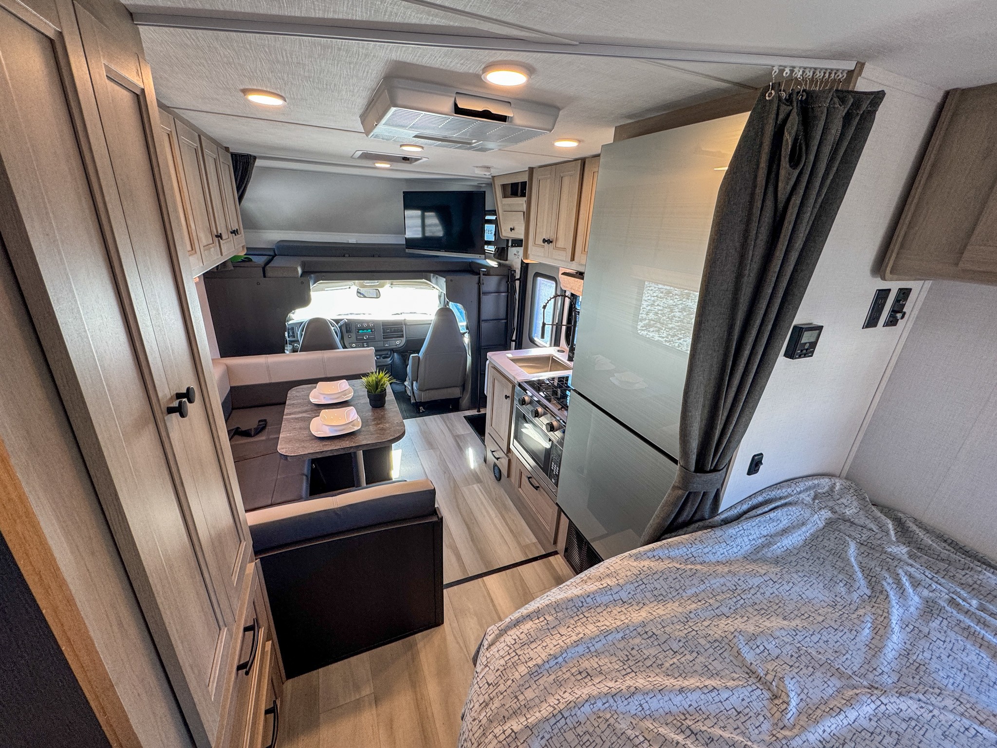 This RV rental interior offers a complete living space with a full kitchen, dinette, comfy bed, and cab-over bunk for travel.. Forest River Sunseeker 2024