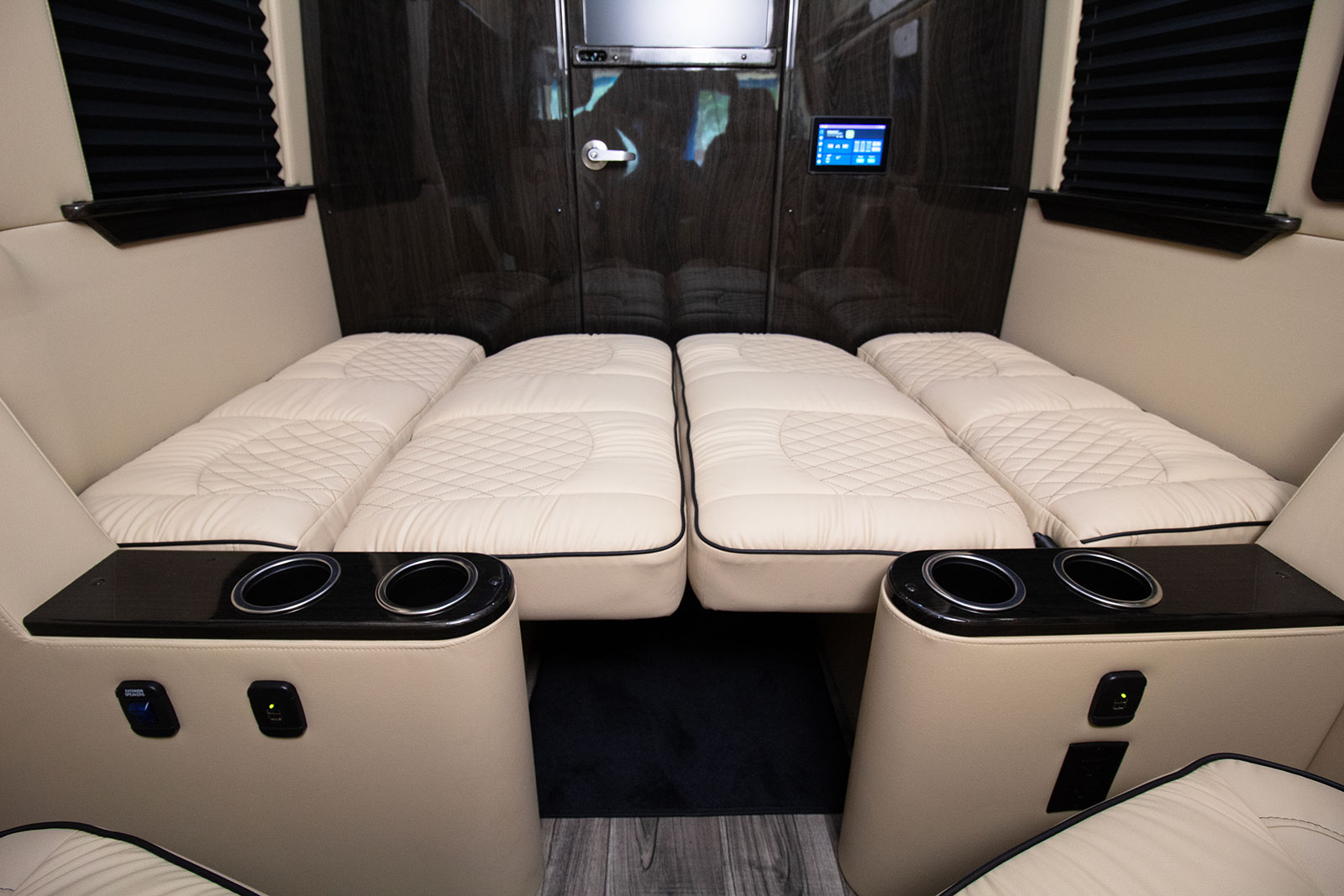 Luxury **RV rental** interior with plush, convertible seating/beds, charging ports, & cup holders for ultimate travel comfort.. Ultimate Toys Ultimate Commuter 144 2022
