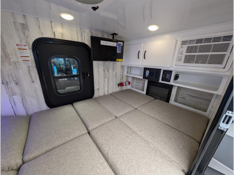 Inside an RV rental: a cozy, well-equipped camper interior with a modular bed, AC, and fireplace for travel comfort.. Modern Buggy Little Buggy 12 LRK 2025