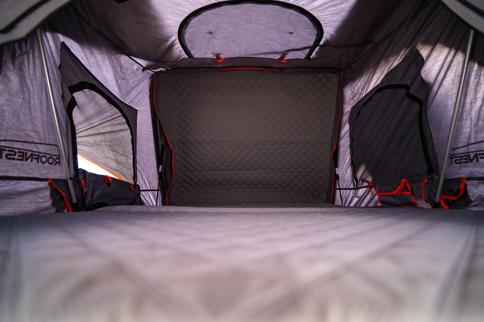 Cozy interior of a Roofnest rooftop tent, featuring a quilted back wall and side vents, ideal for your RV rental adventure.. Toyota Tacoma TRD Off Road 2017
