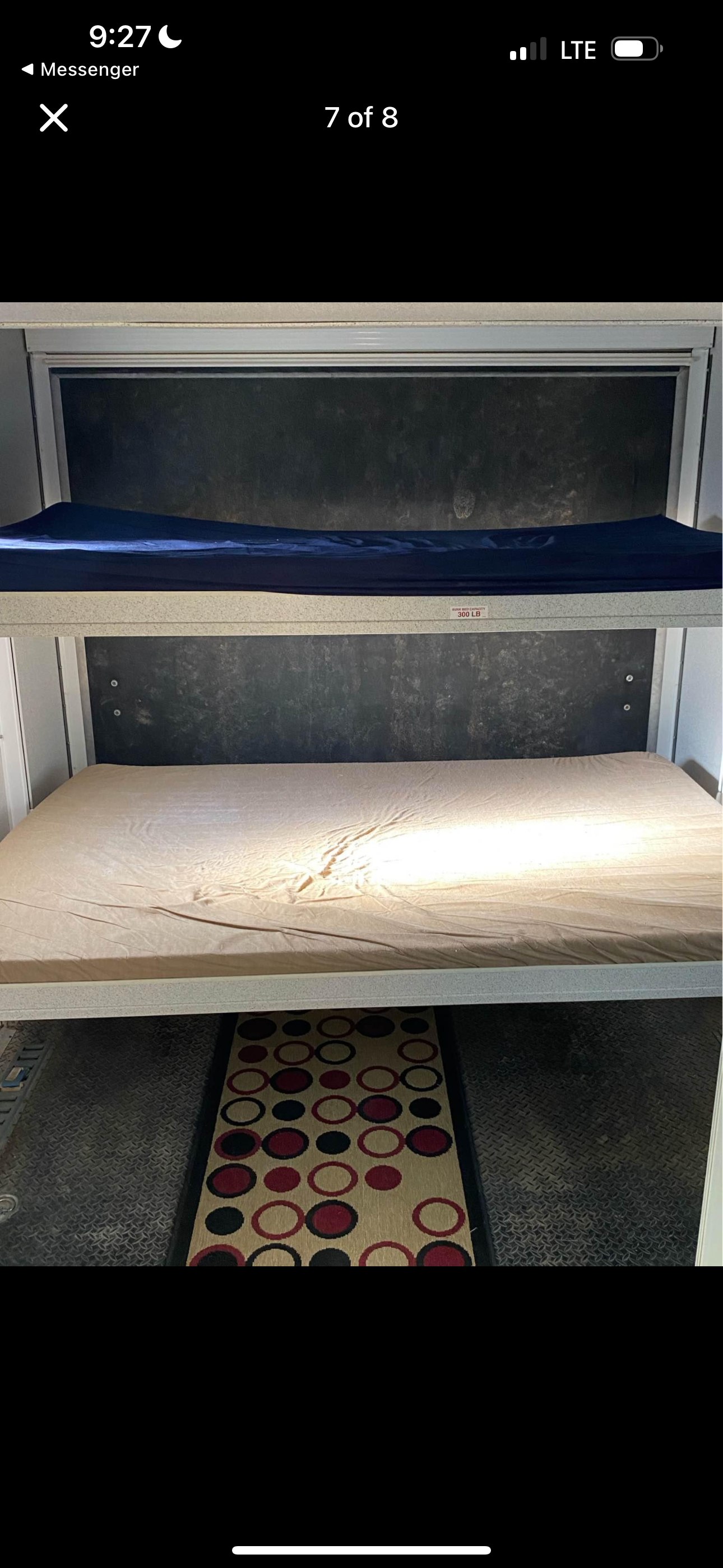 RV rental bunk beds (300 lb capacity) with blue and tan mattresses, above a patterned rug on diamond plate flooring.. Heartland RVs Cyclone Toy Hauler 2008