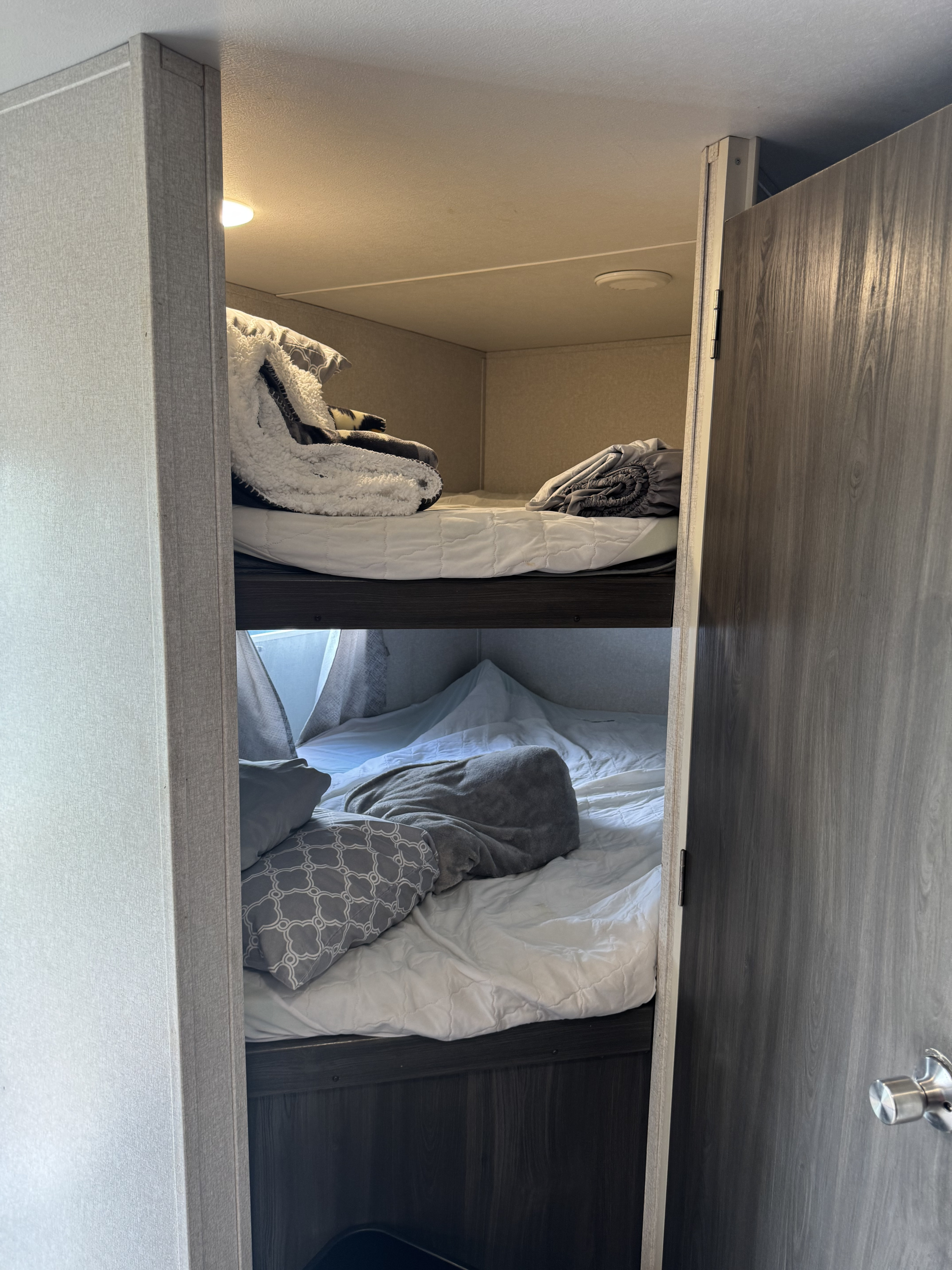 RV rental bunk beds: a compact, comfy sleeping area with neatly made top and inviting lower bunks.. Forest River Shasta 2020